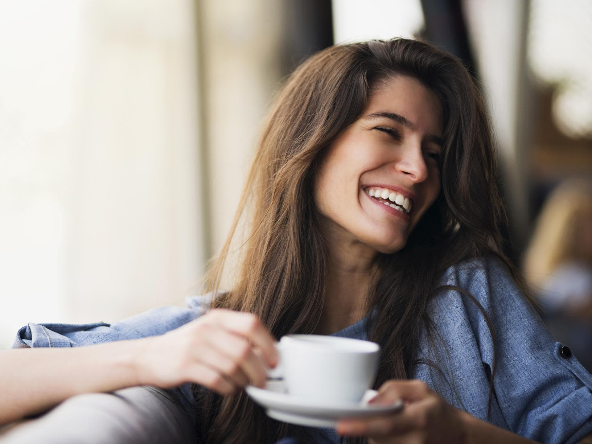 Lächelnde Frau mit Kaffeetasse in der Hand
