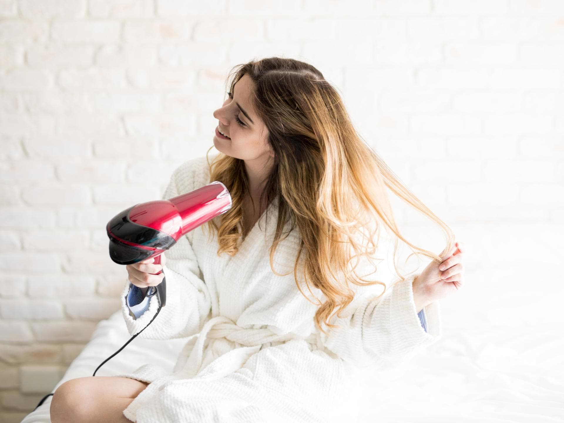 Frau föhnt sich die Haare
