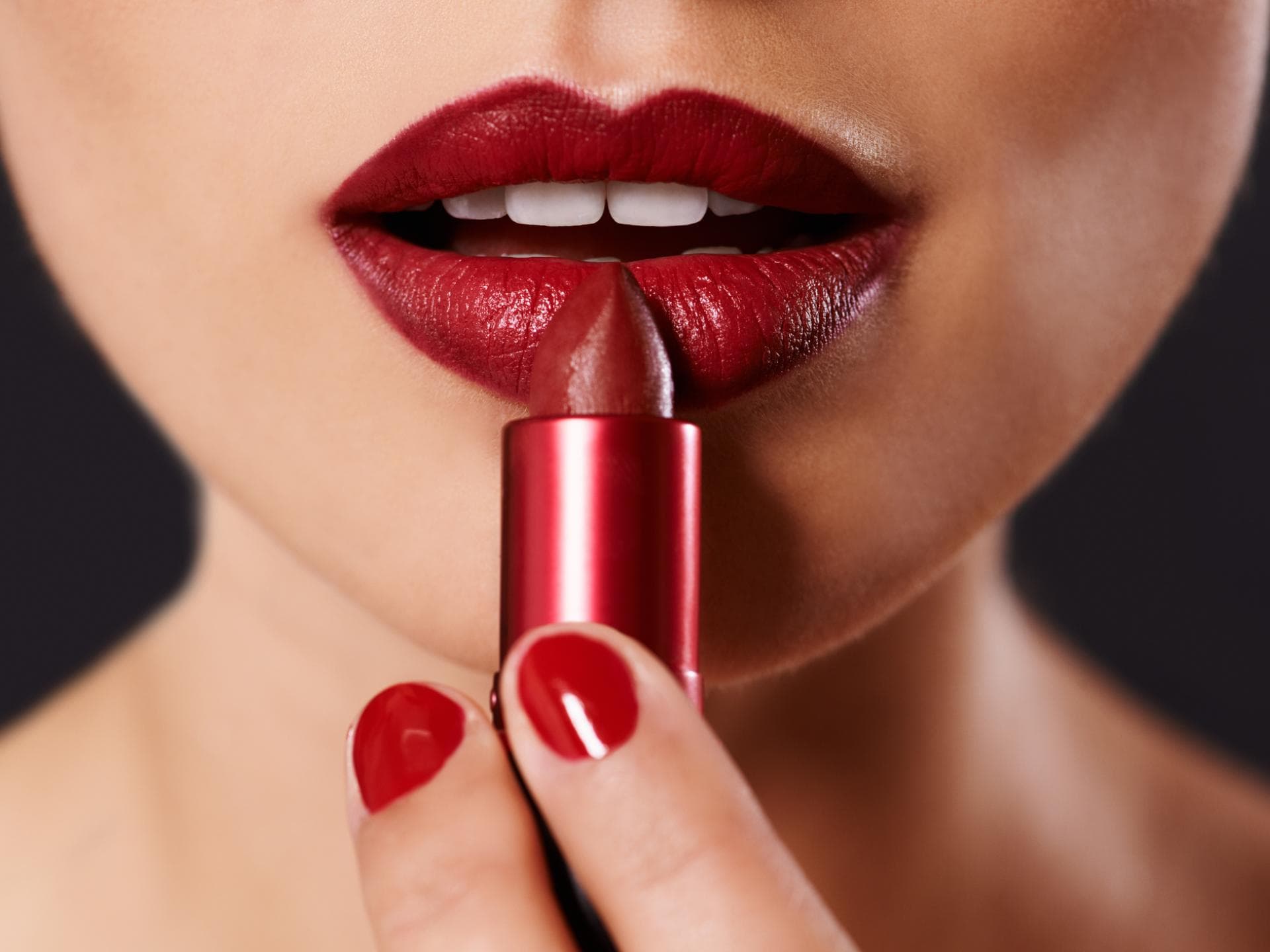 Junge Frau trägt roten Lippenstift auf