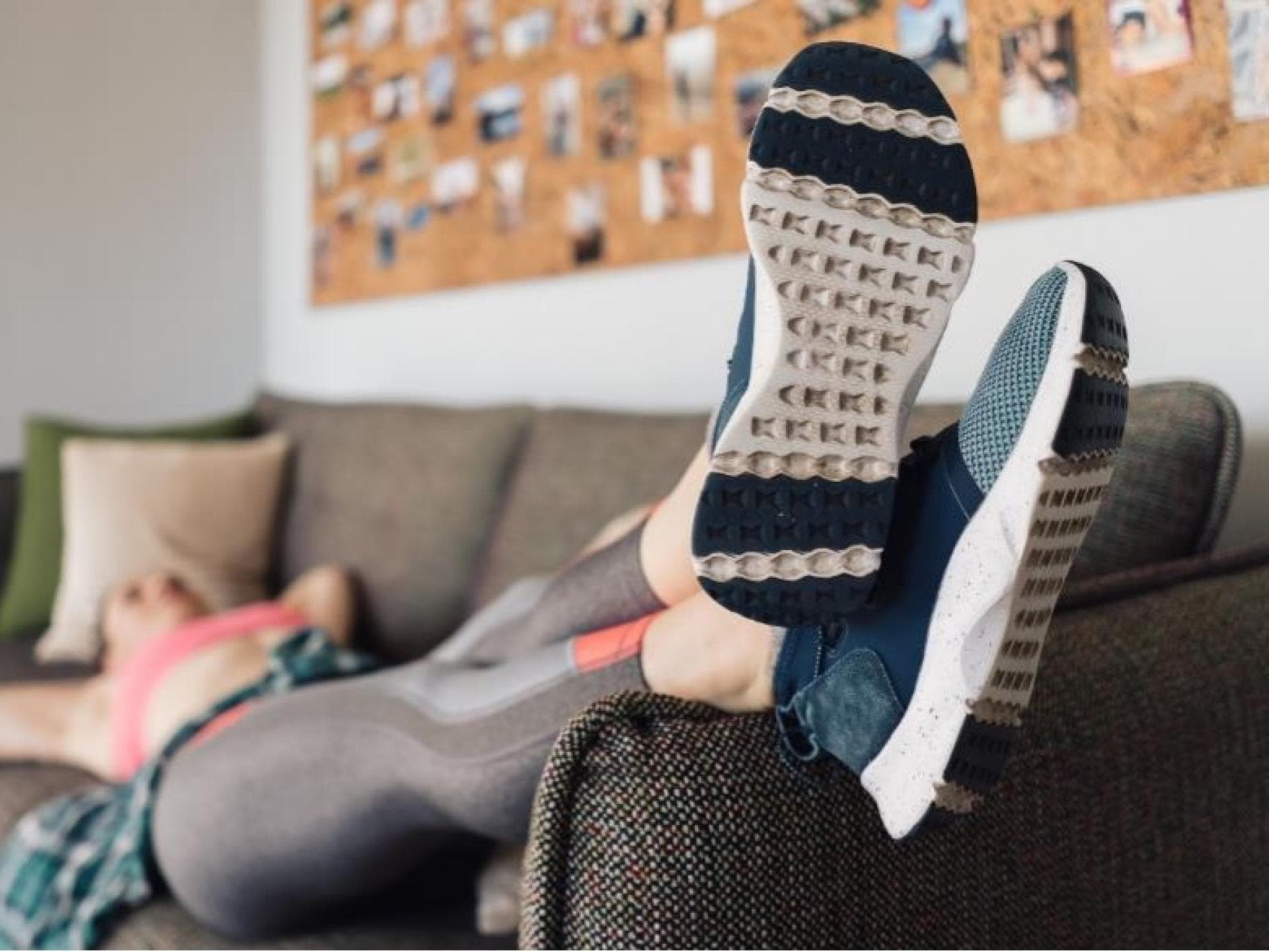 Frau in Sportkleidung auf der Couch 