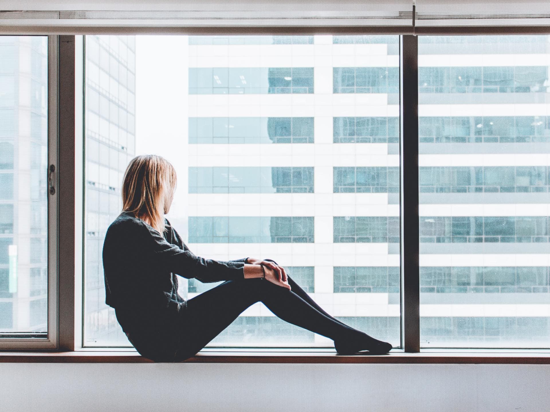 Frau sitzt am Fenster Frau sitzt am Fenster