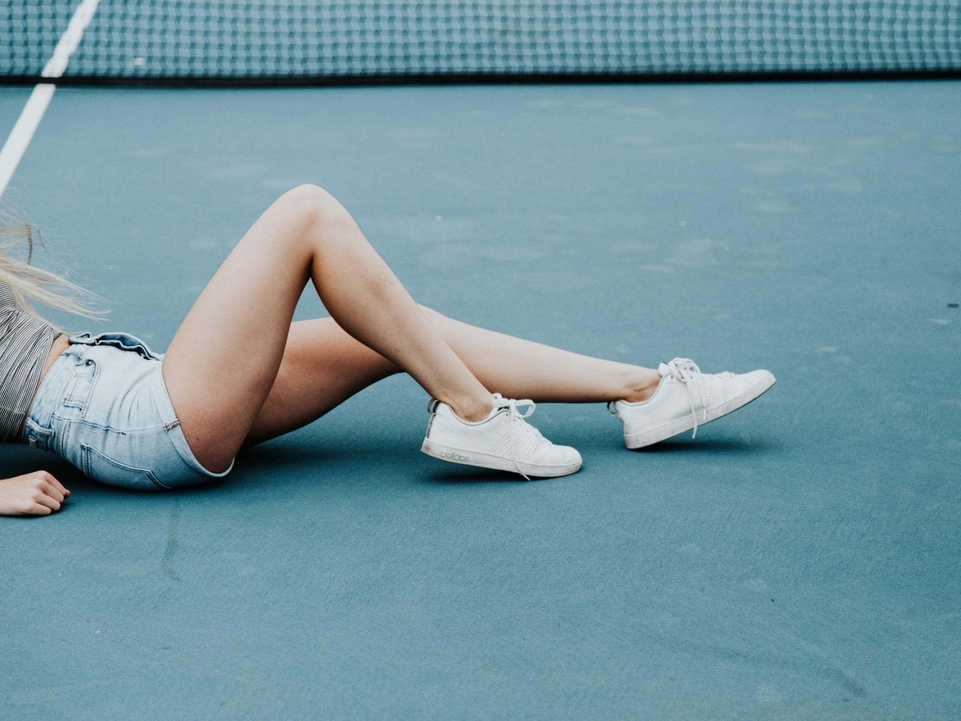 Frau mit nackten Beinen auf Tennisplatz