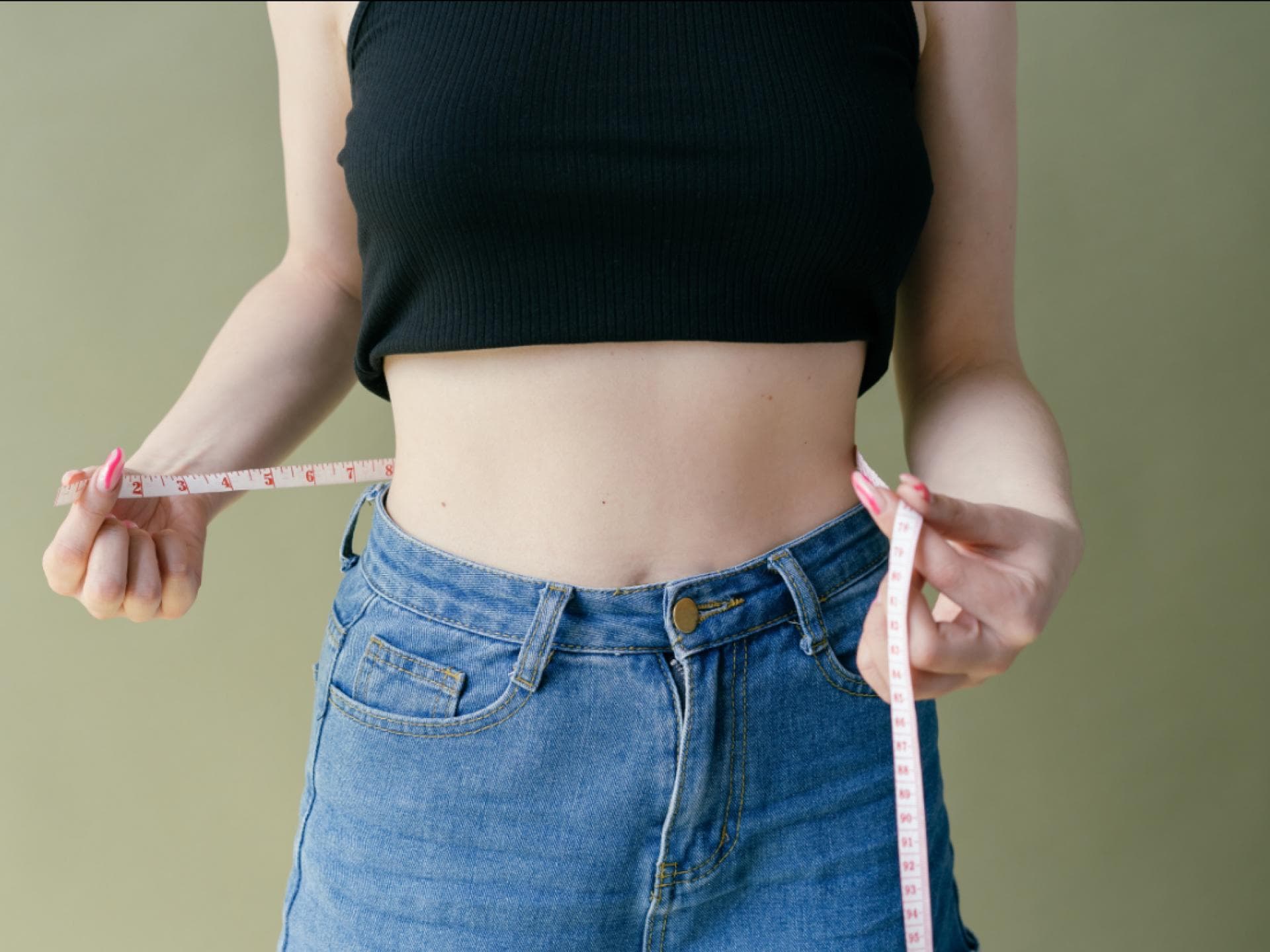 schlanke Frau misst Bauch mit Maßband schlanke Frau misst Bauch mit Maßband
