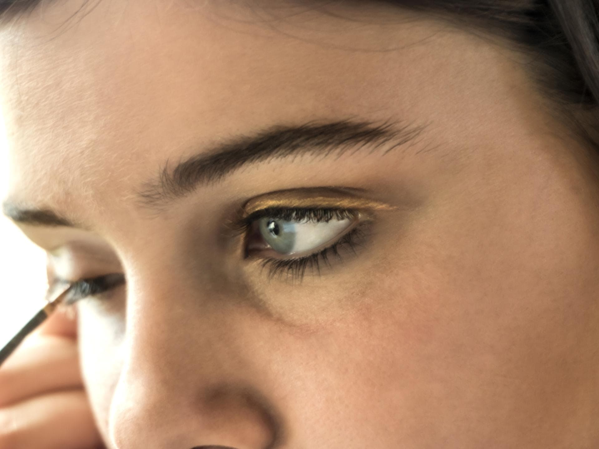 Frau trägt Eyeliner auf 