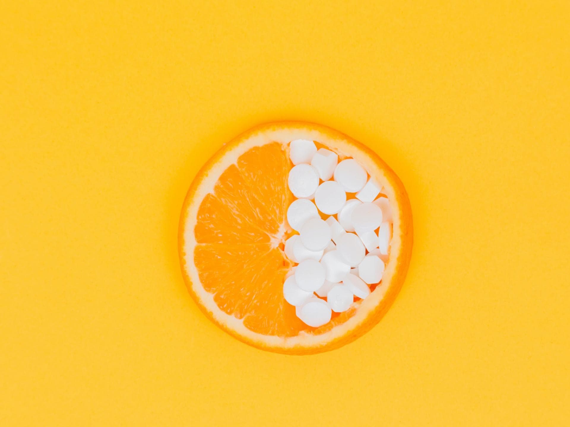 Orange mit Vitamintabletten