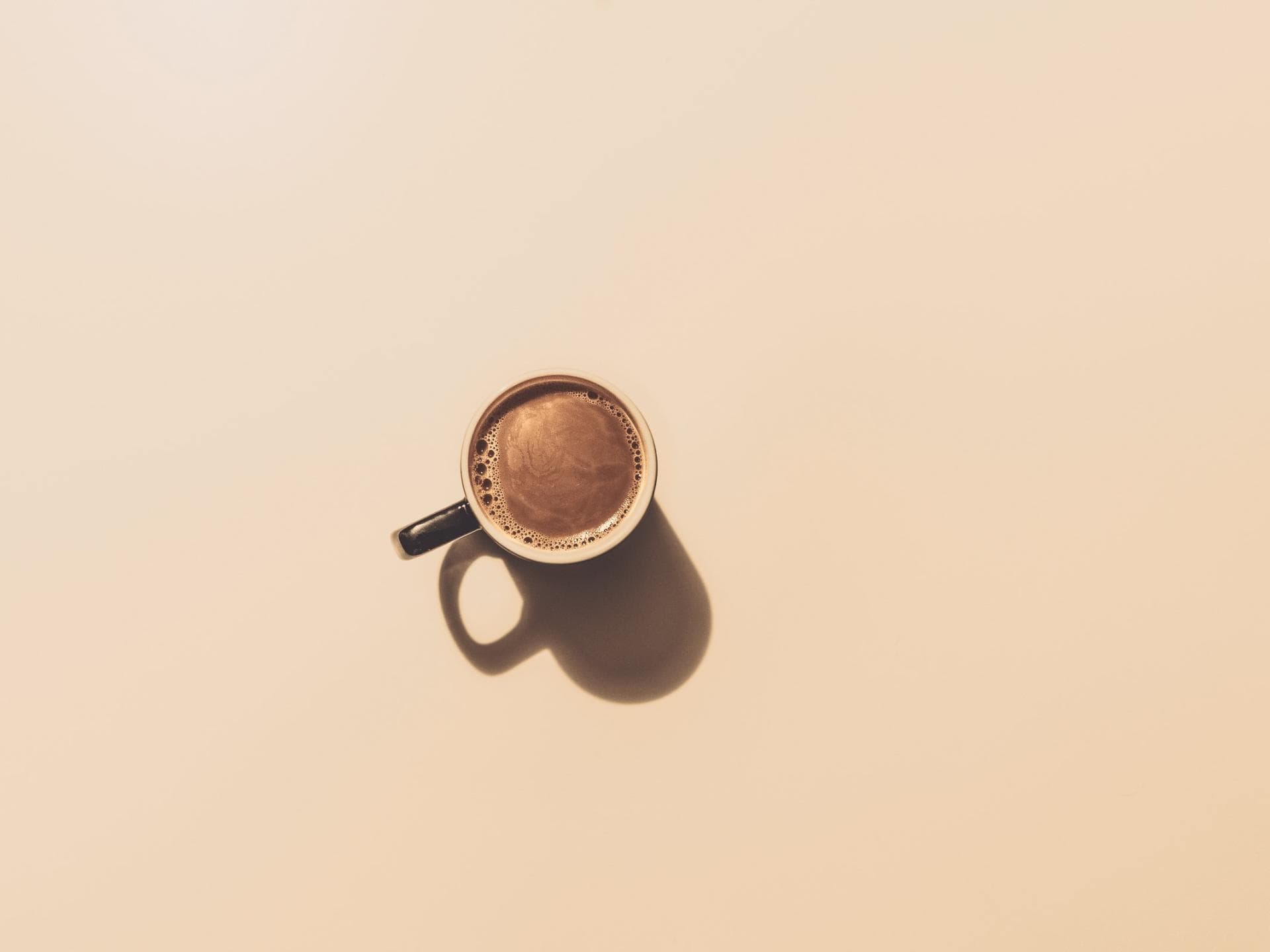 Kaffeetasse auf braunem Hintergrund.