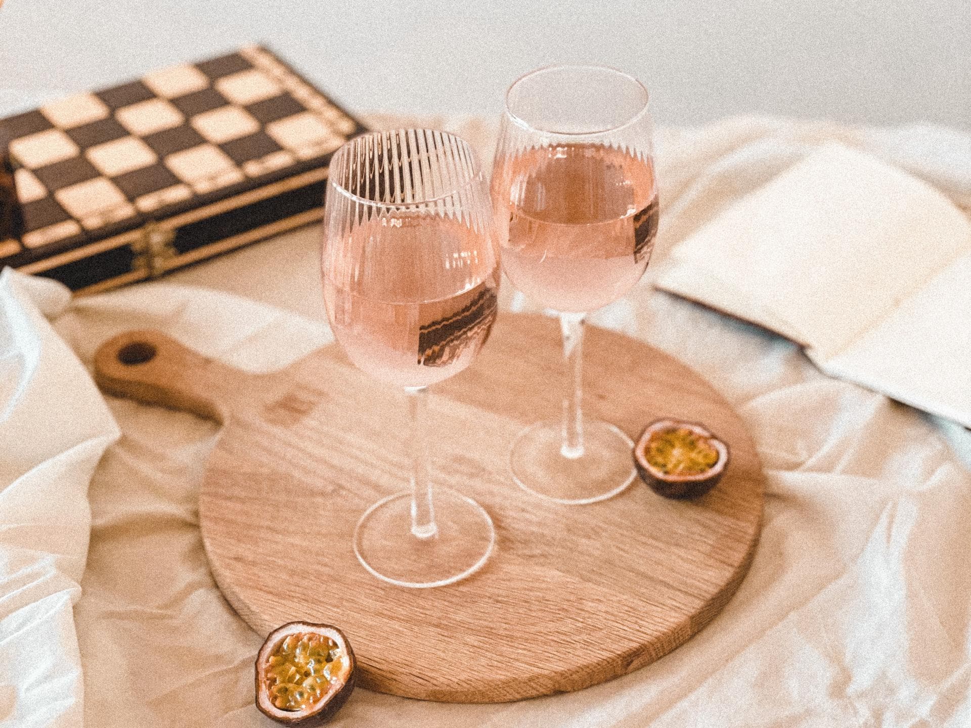 Zwei Gläser Rosé stehen auf einem Holzbrett. Zwei Gläser Rosé stehen auf einem Holzbrett.