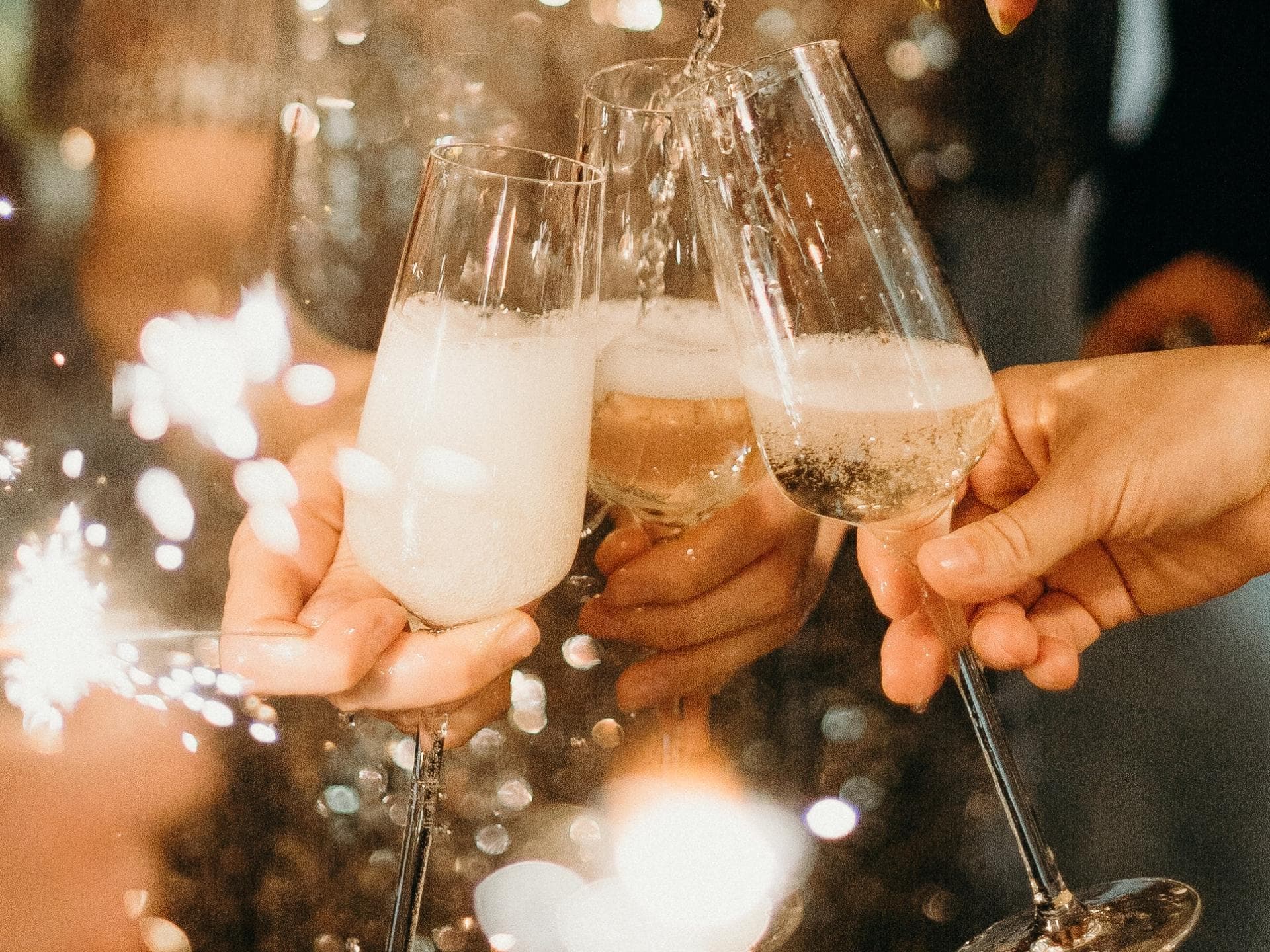 Mehrere Personen stoßen mit Sekt an.