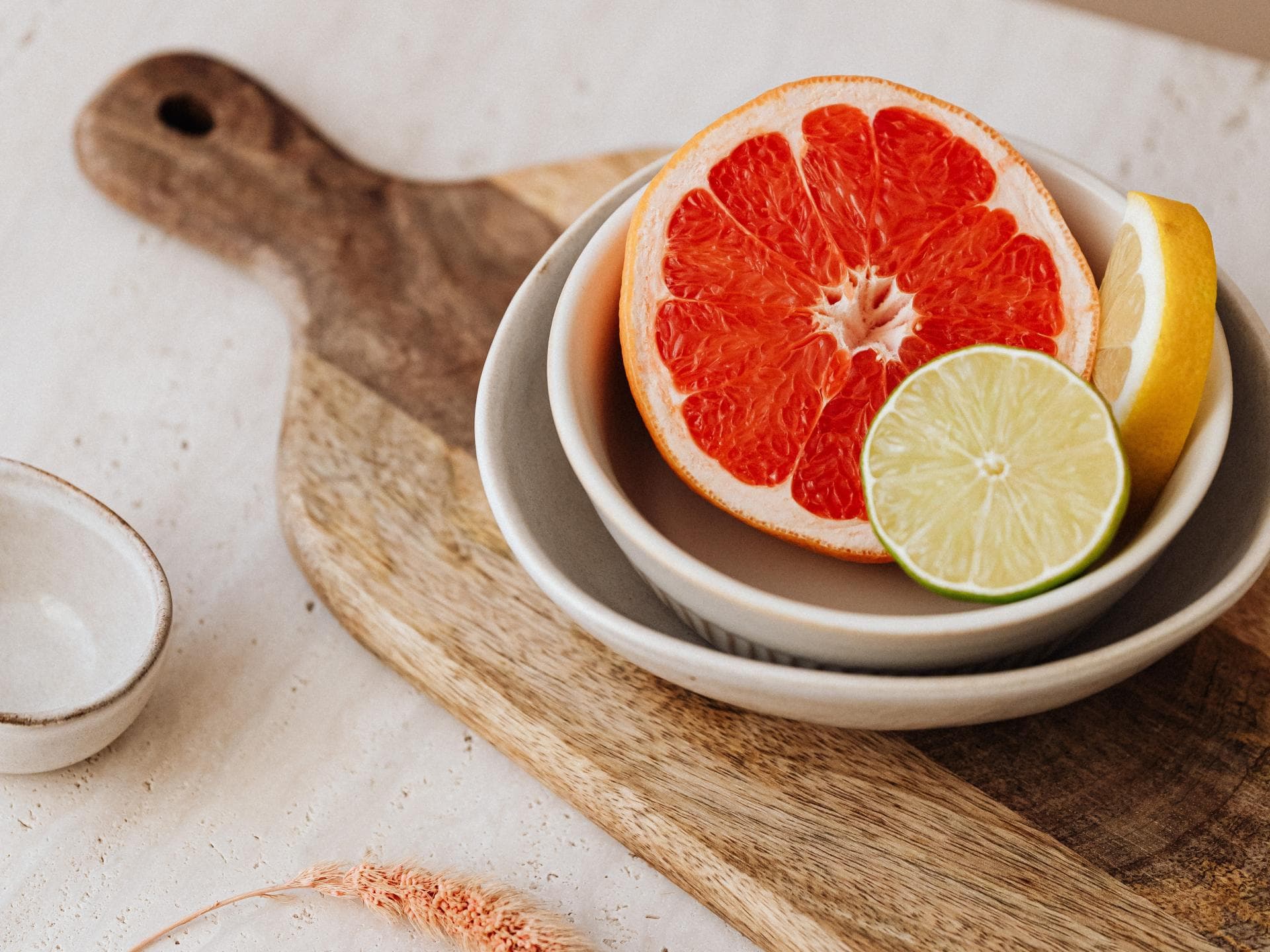 Eine halbe Grapefruit liegt auf einem Schneidebrett.