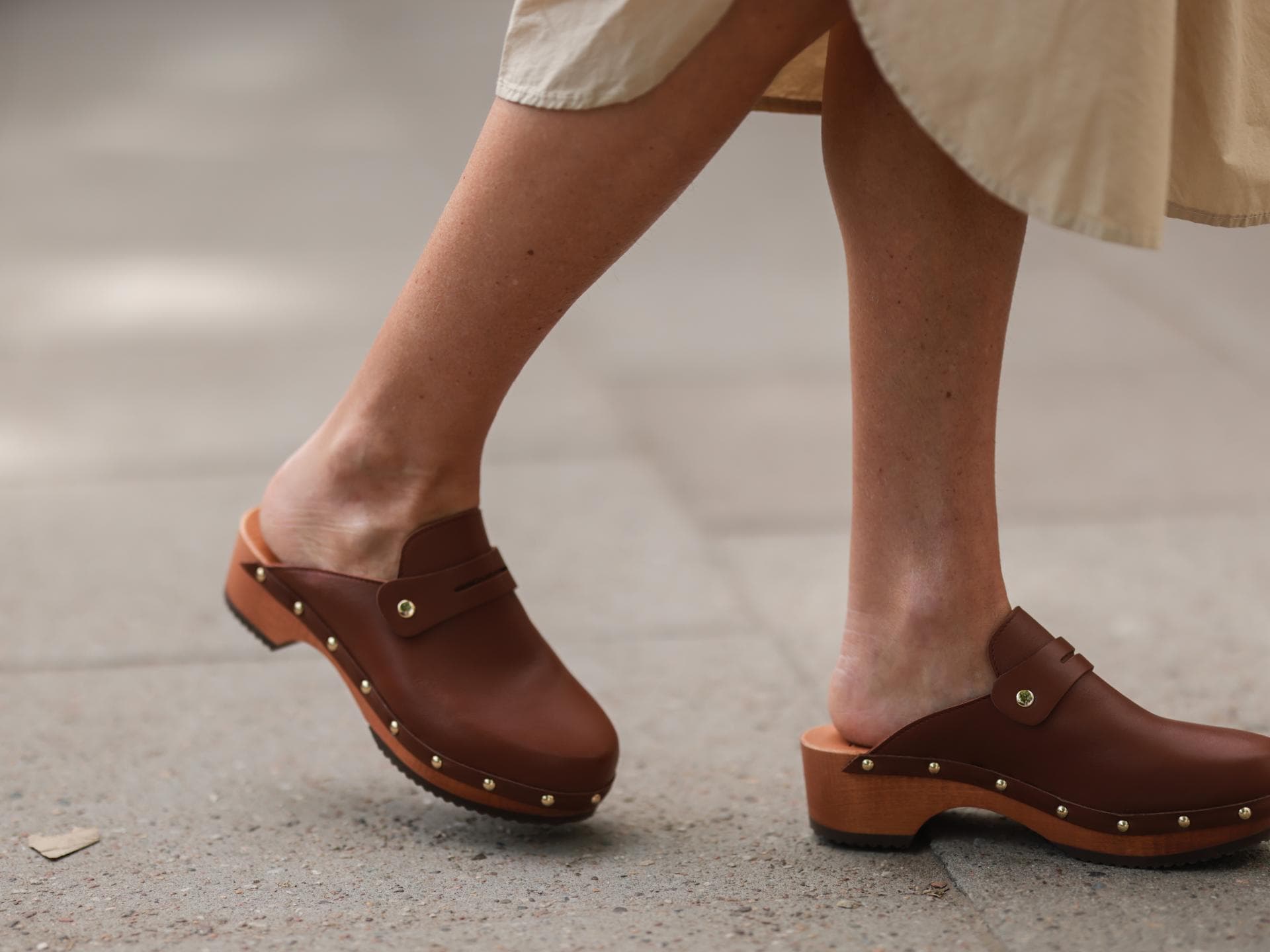 Frau trägt braune Clogs im Streetstyle