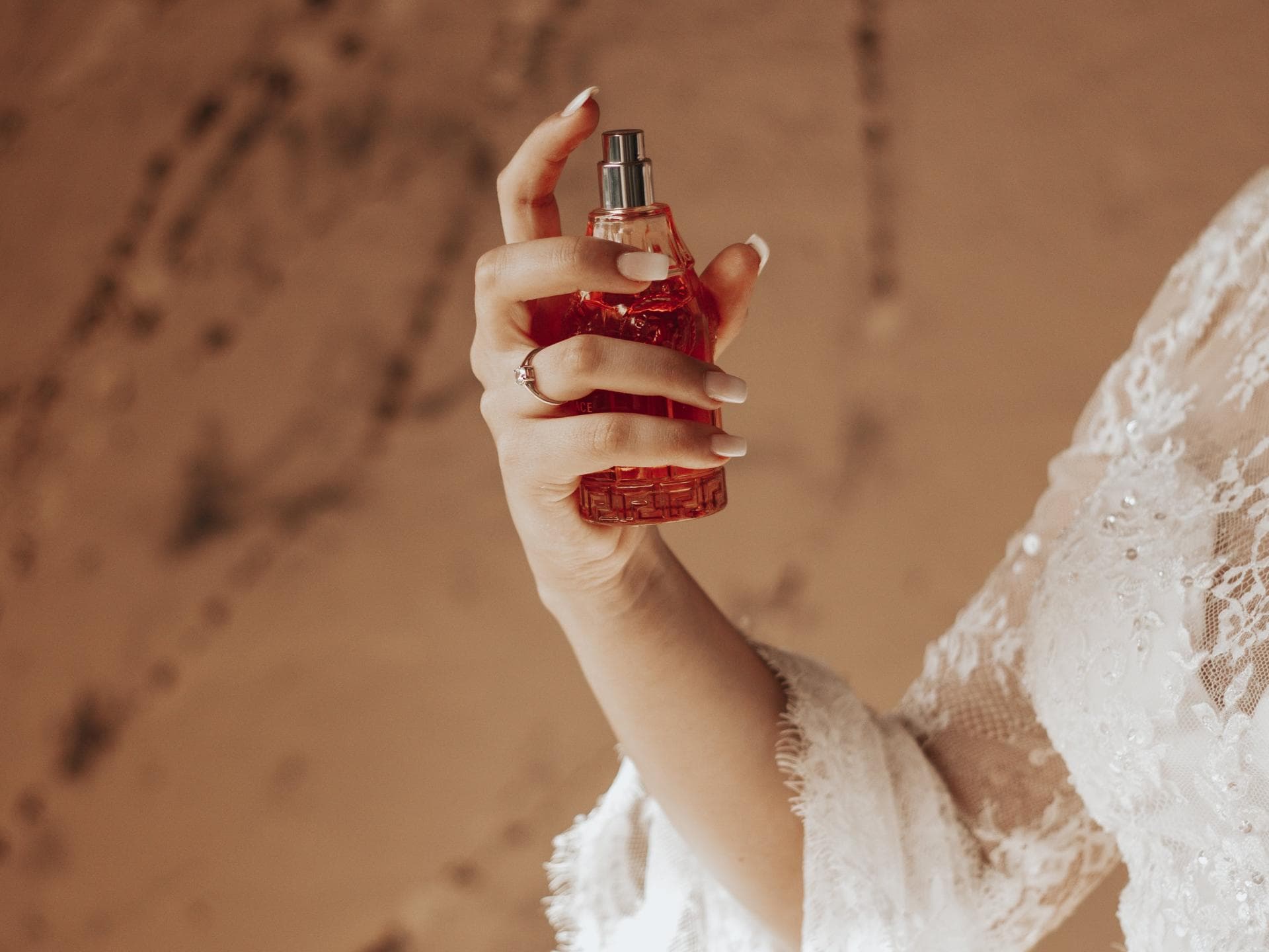 Frau trägt Parfum mit Amber auf.