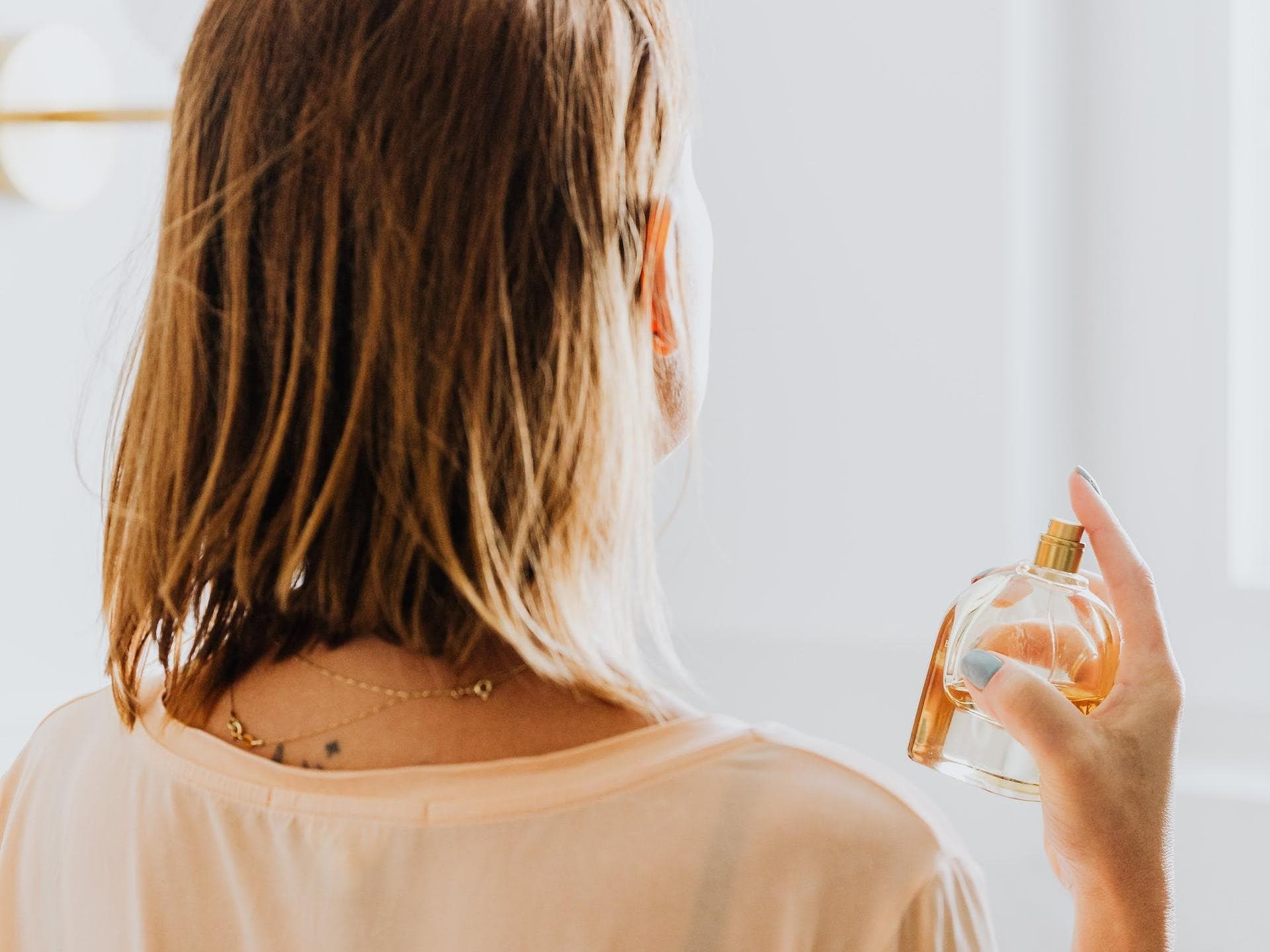 Frau sprüht Parfum wie frische Wäsche