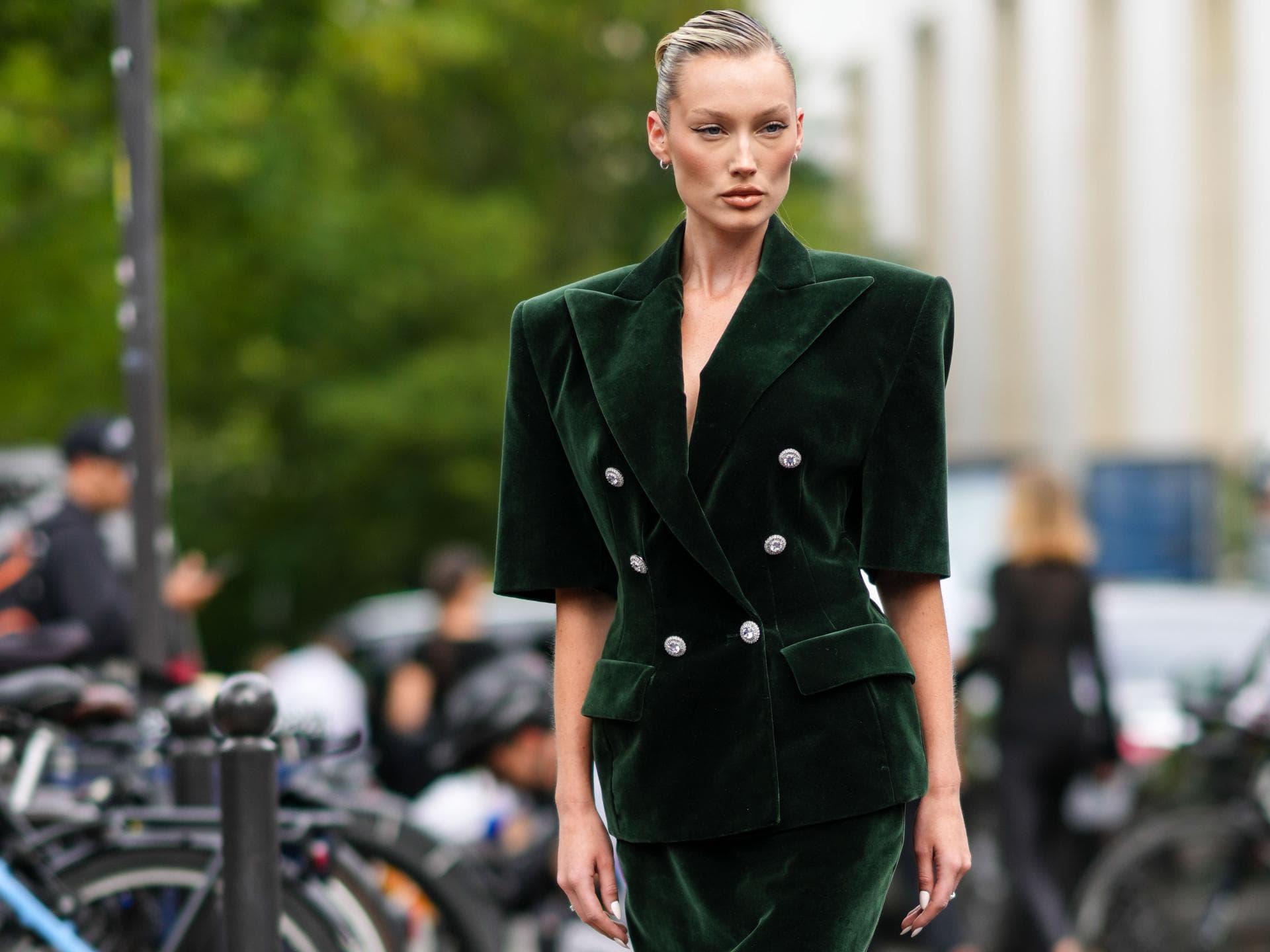 Frau trägt ein grünes Samtkleid im eleganten Streetstyle.