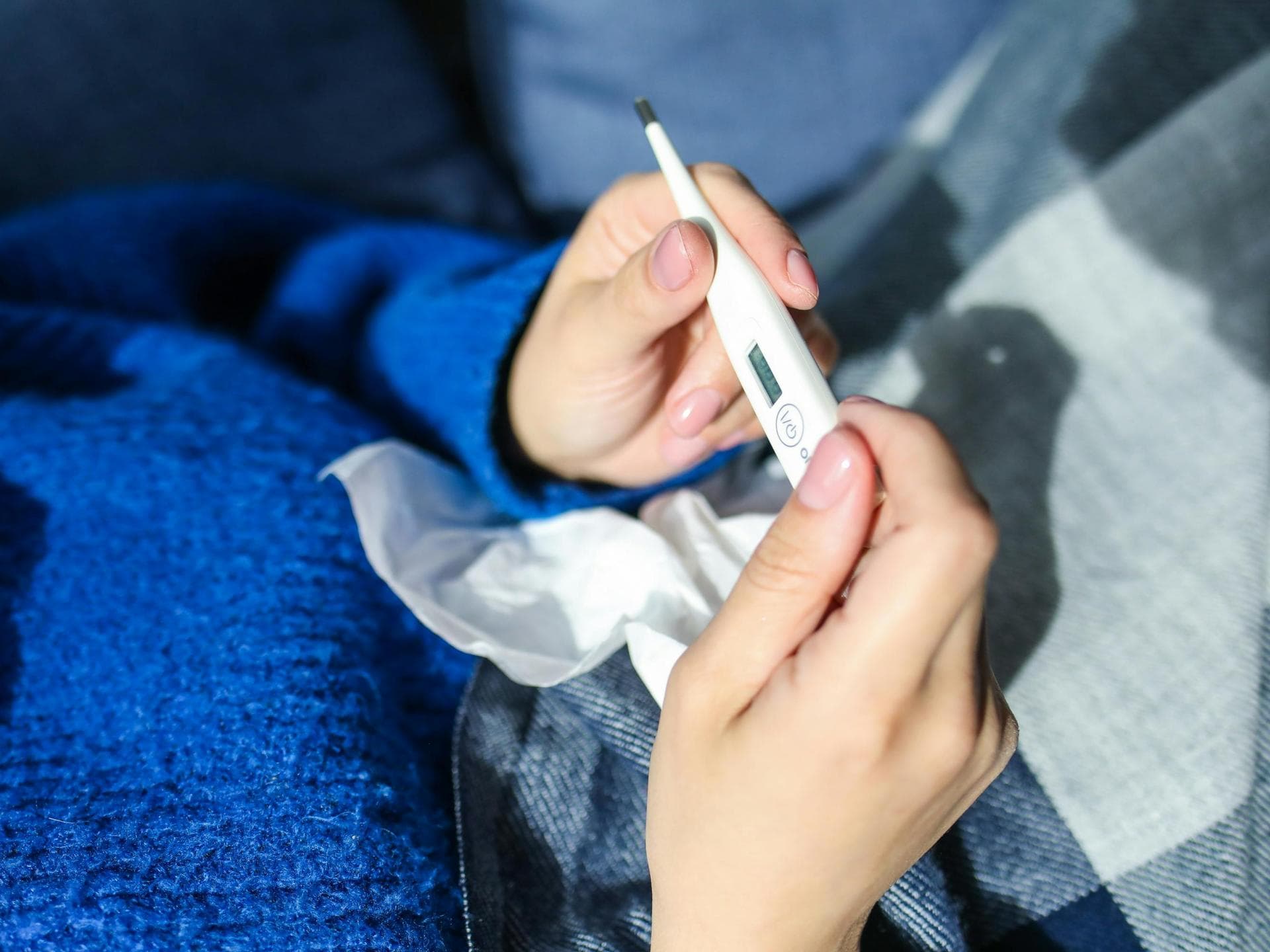 Frau hält Fieberthermometer