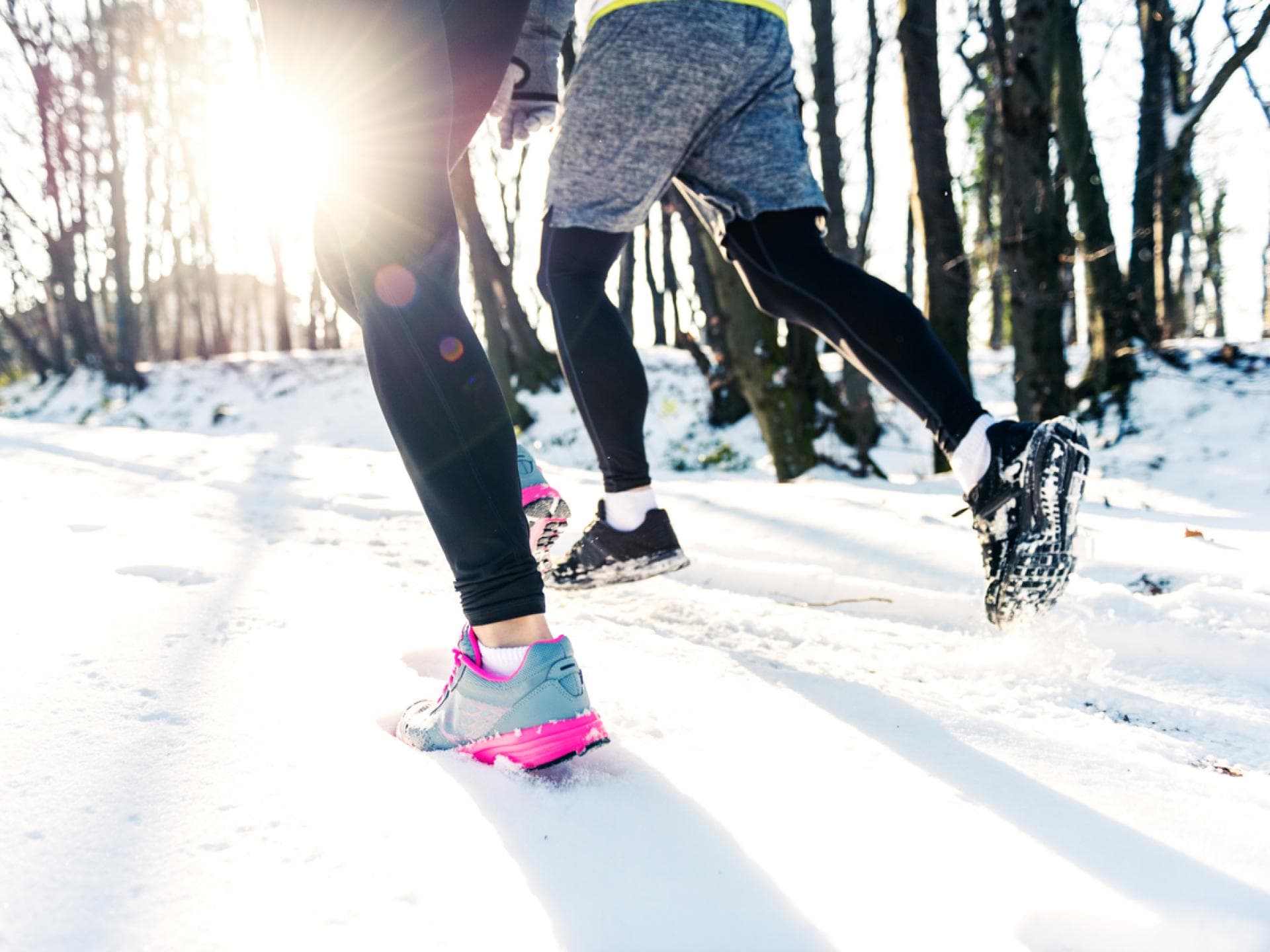 Zwei Personen joggen im Winter.