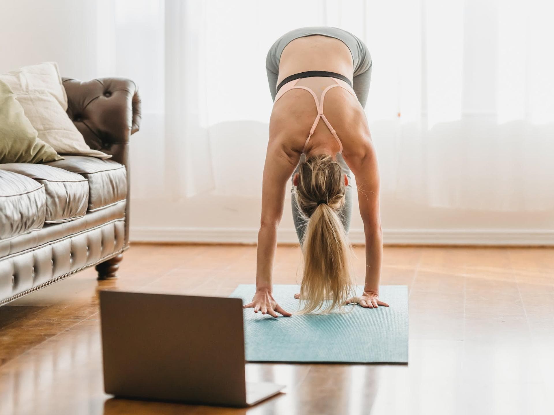 Frau macht Online Fitnesskurse auf einer Sportmatte