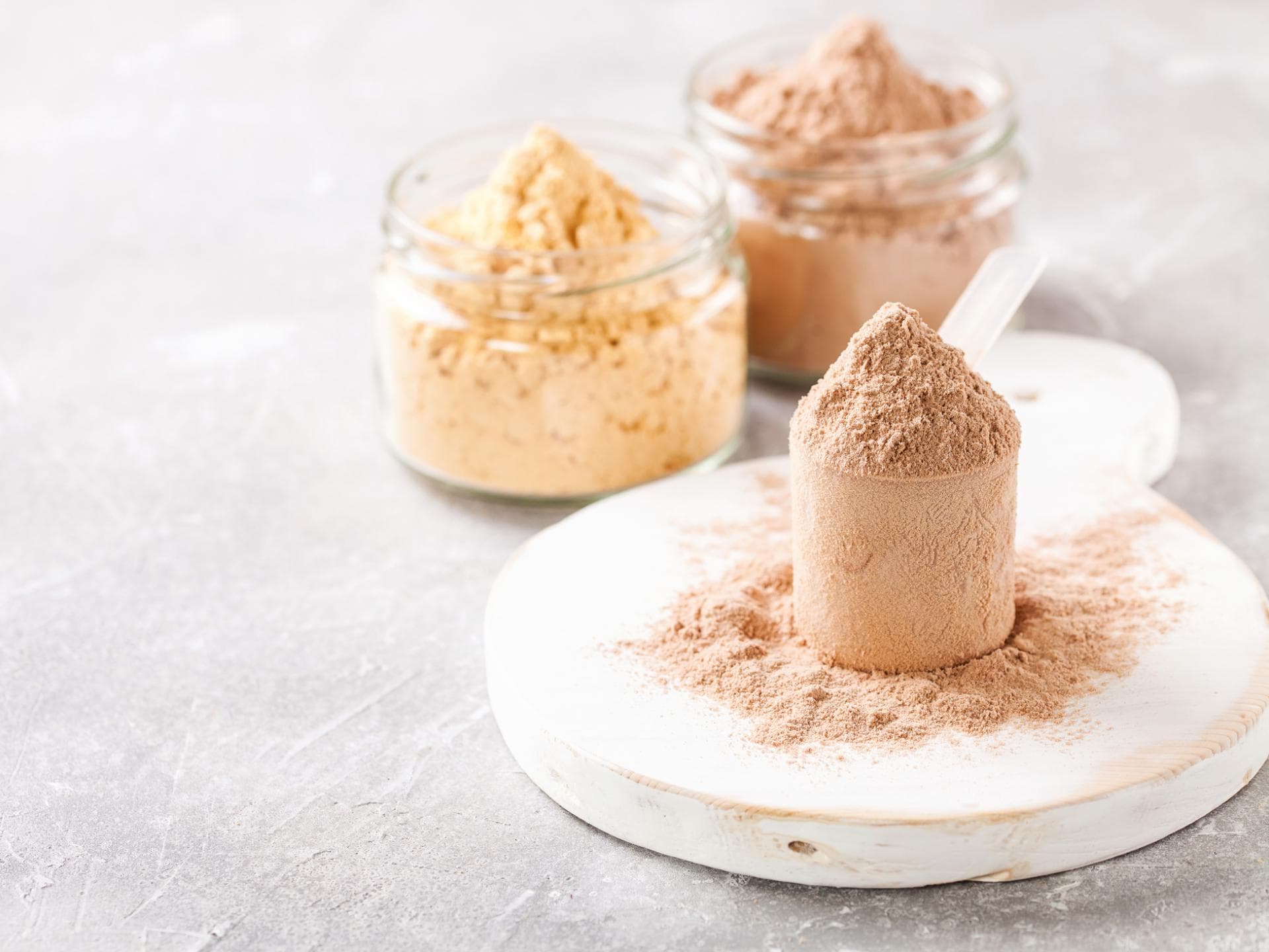 Proteinpulver im Glas und Löffel