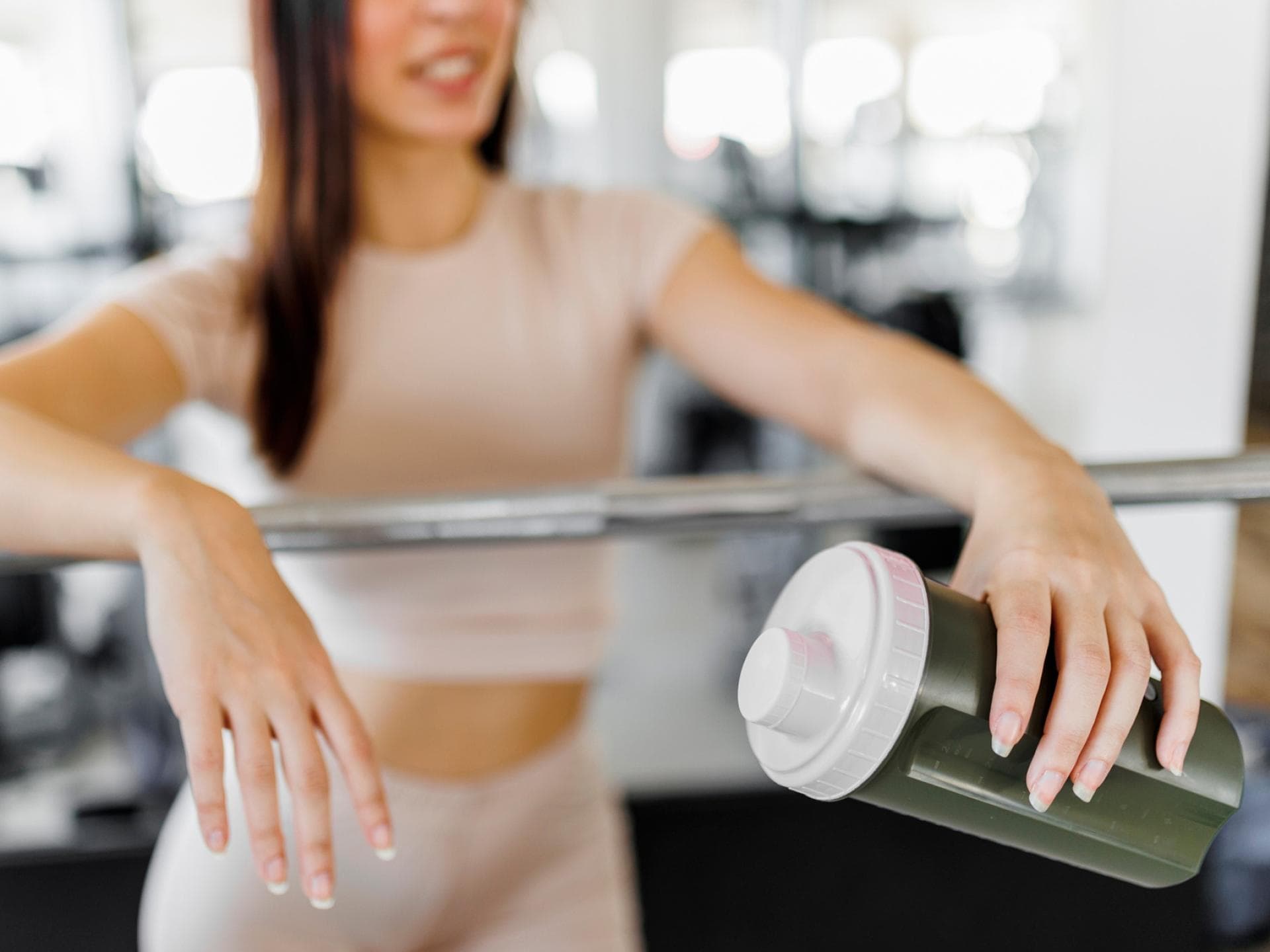 Frau mit Eiweißshake beim Training