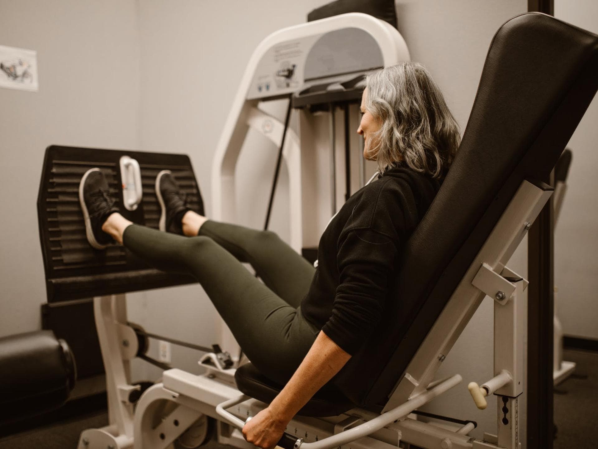 Eine Frau auf der Beinpresse macht Krafttraining ab 60 Jahren.