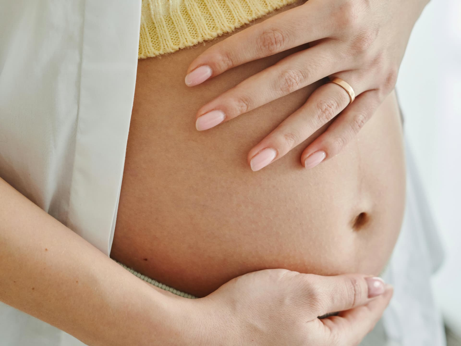 Frau streichelt ihren Babybauch Frau streichelt ihren Babybauch