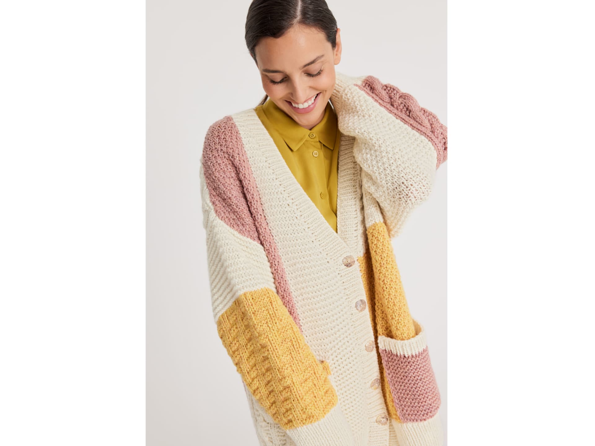 Model in rosa, weißer und gelber Strickjacke von Lana Grossa