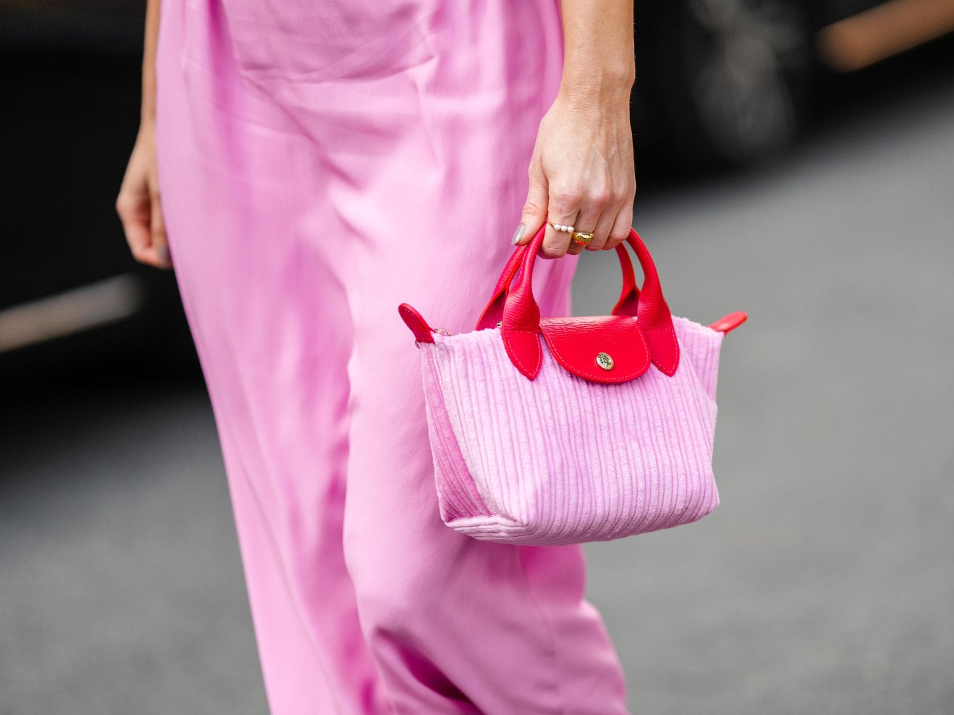 Frau trägt pinke Longchamp-Tasche im Streetstyle Frau trägt pinke Longchamp-Tasche im Streetstyle