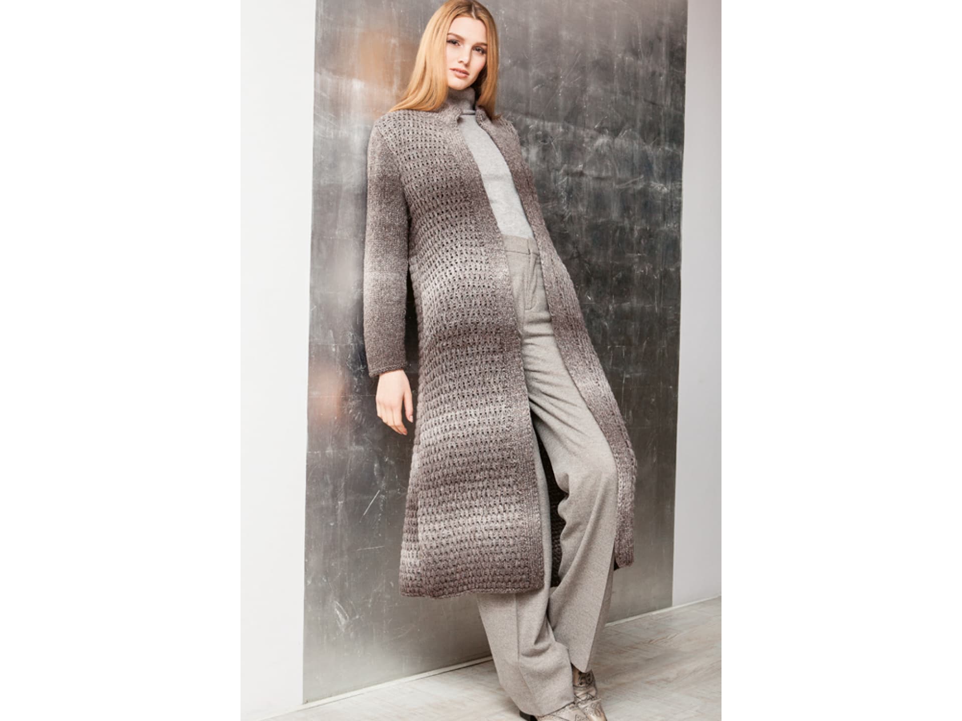 Model in Strickmantel mit Hebemaschenmuster