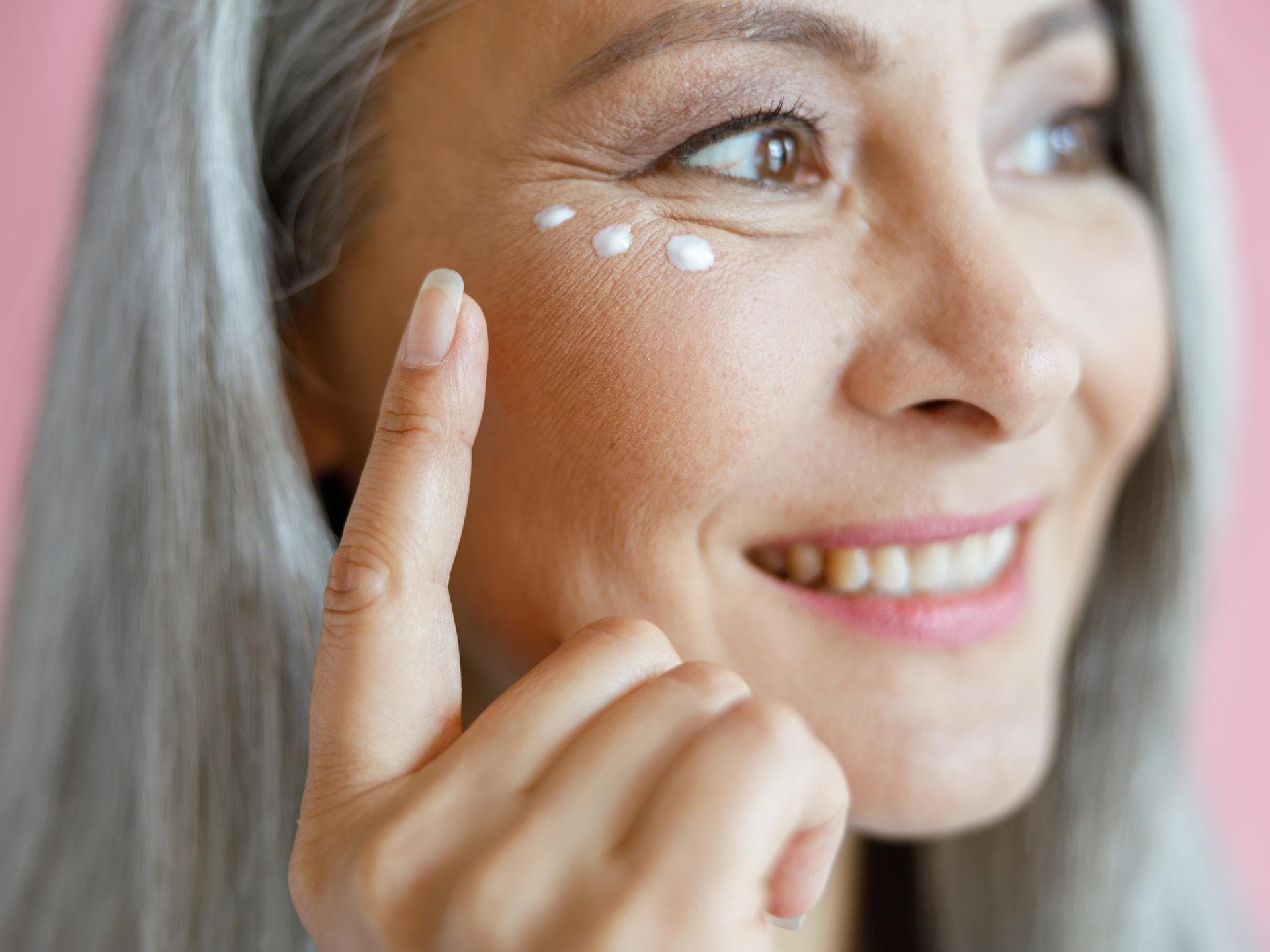 Ältere Frau mit Augencreme