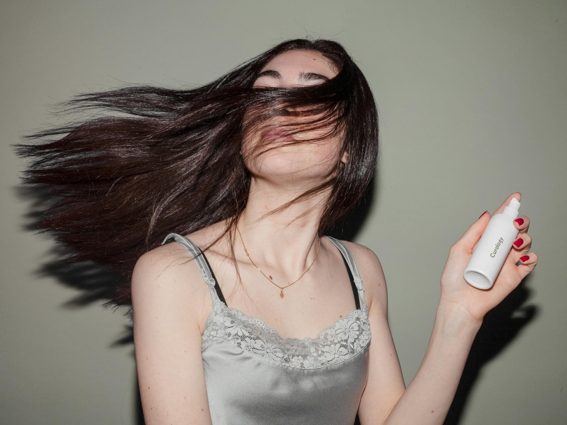 Frau mit vollem Haar und Sprühflasche in der Hand