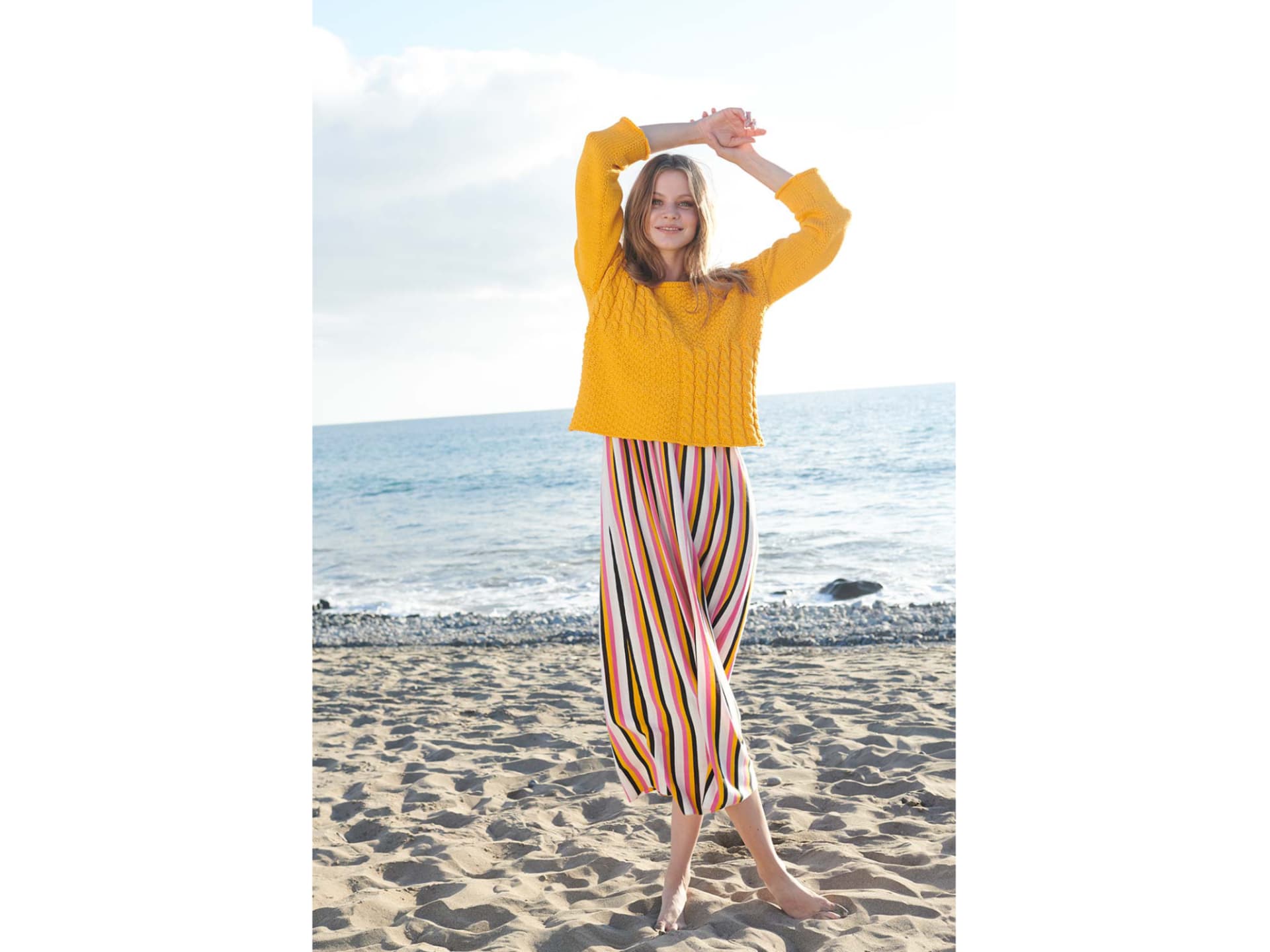 Model in gelbem Sommerpulli mit Zopfmuster
