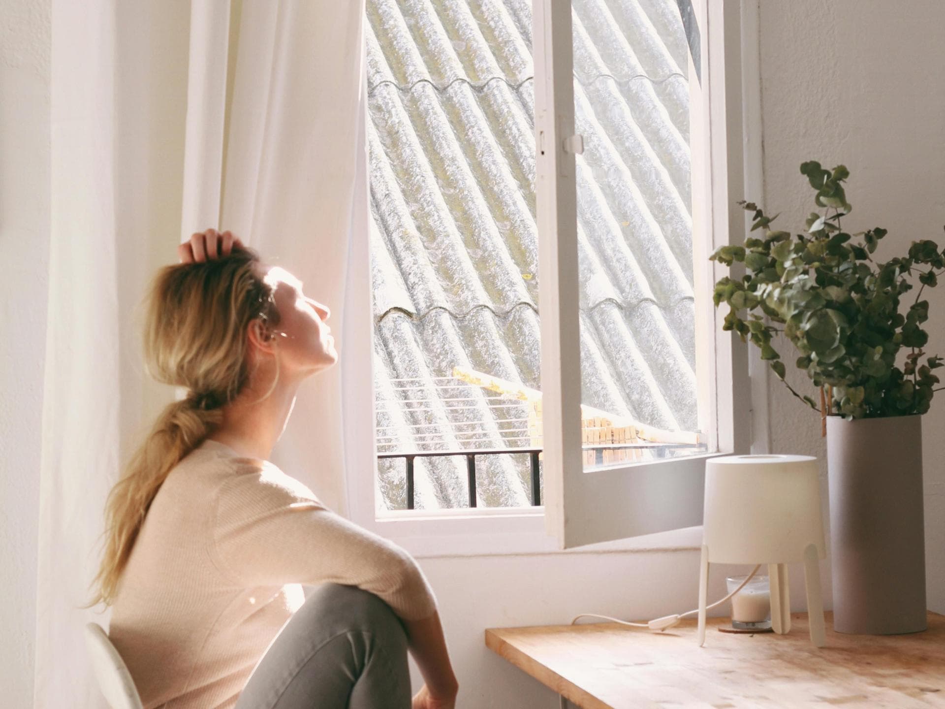 Frau an offenem Fenster