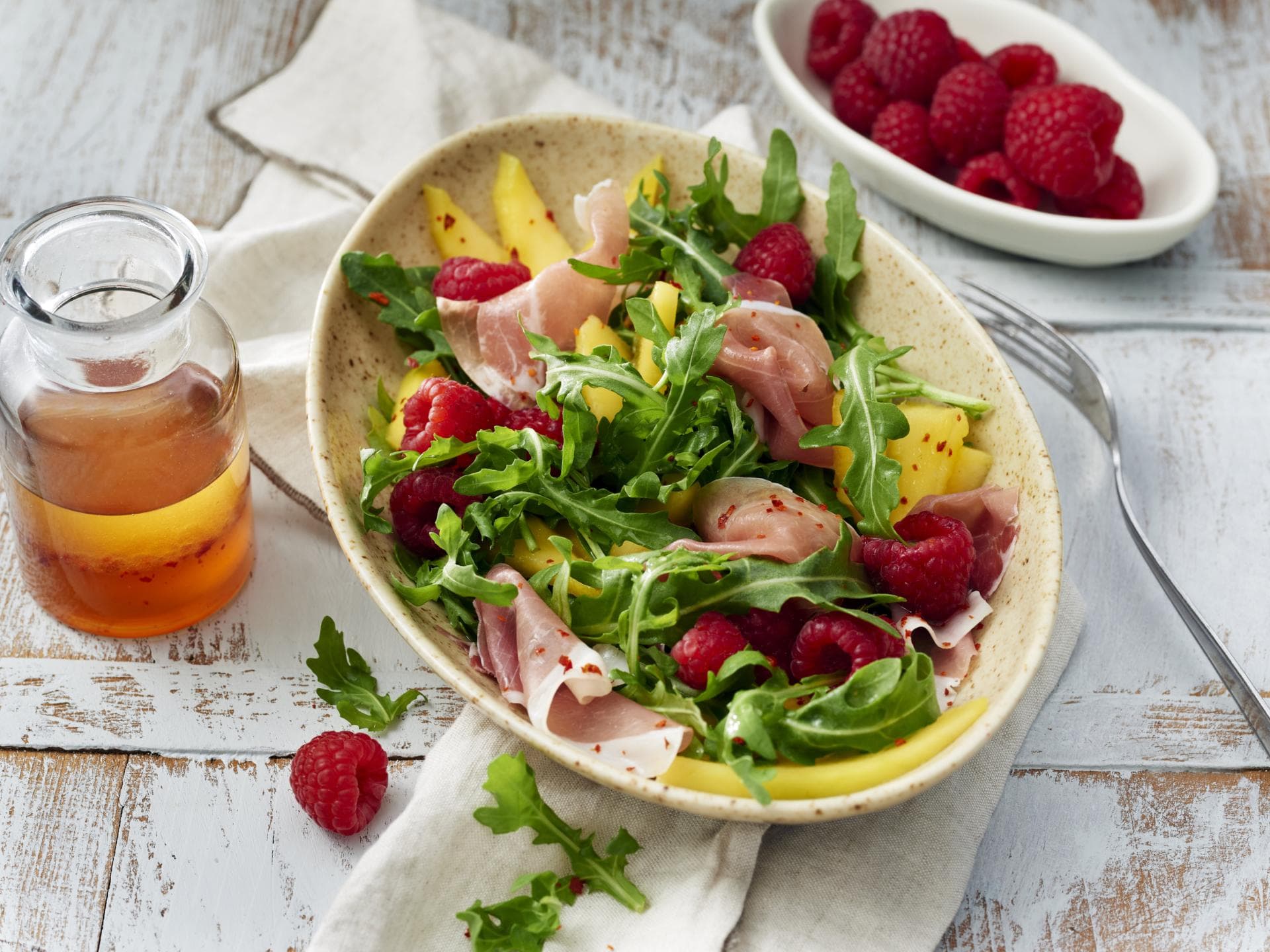 Rucolasalat mit Mango, Himbeeren und Schinken 