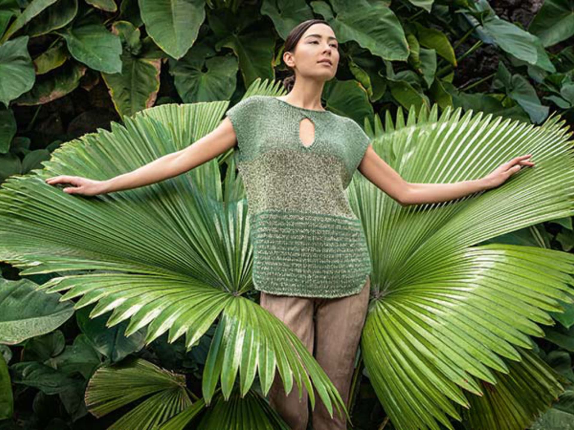 Model in grünem Sommershirt mit Lochdetail
