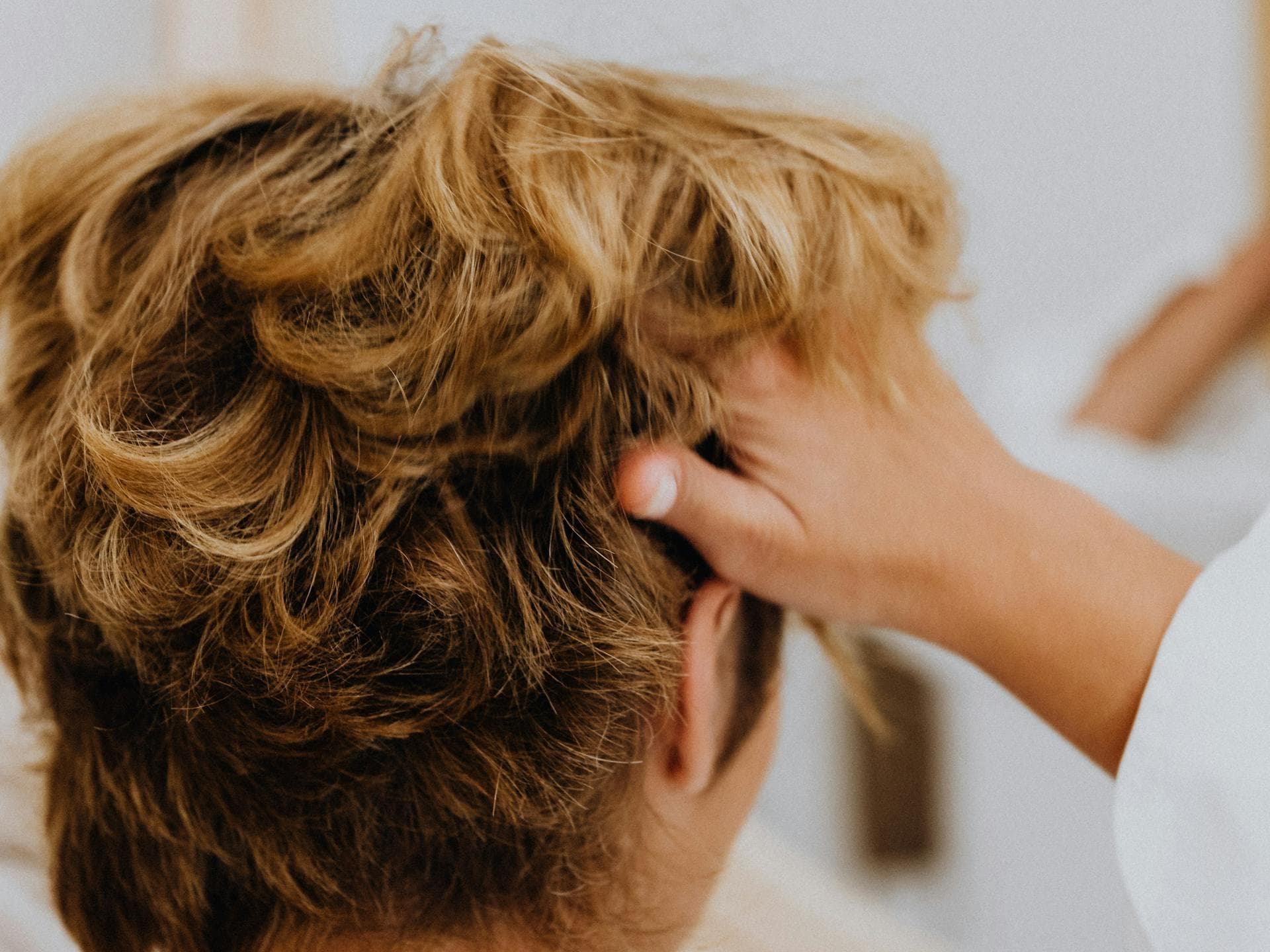 Frau geht sich mit den Fingern durch die Haare