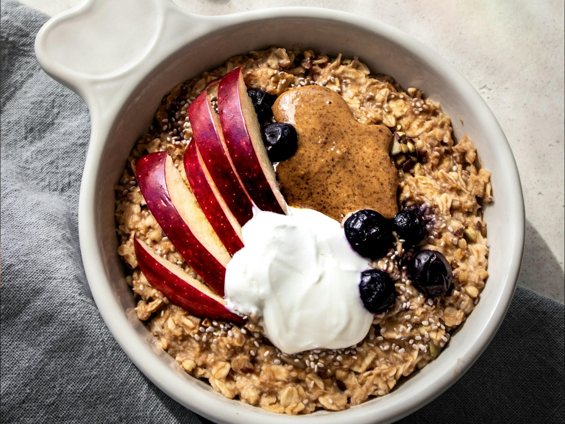 Schüssel mit Porridge, Mandelmus und Obst