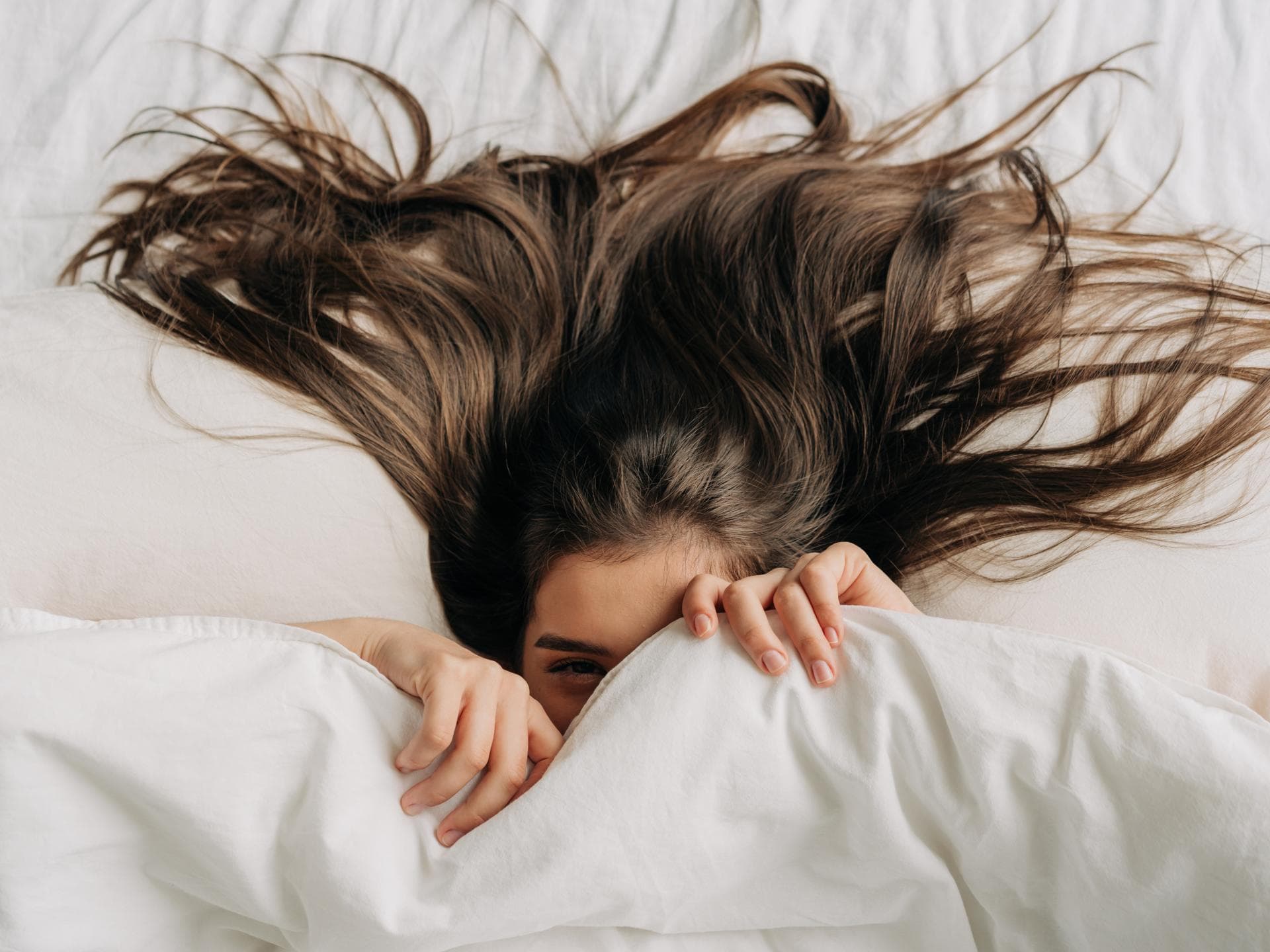 Frau mit langen Haaren im Bett