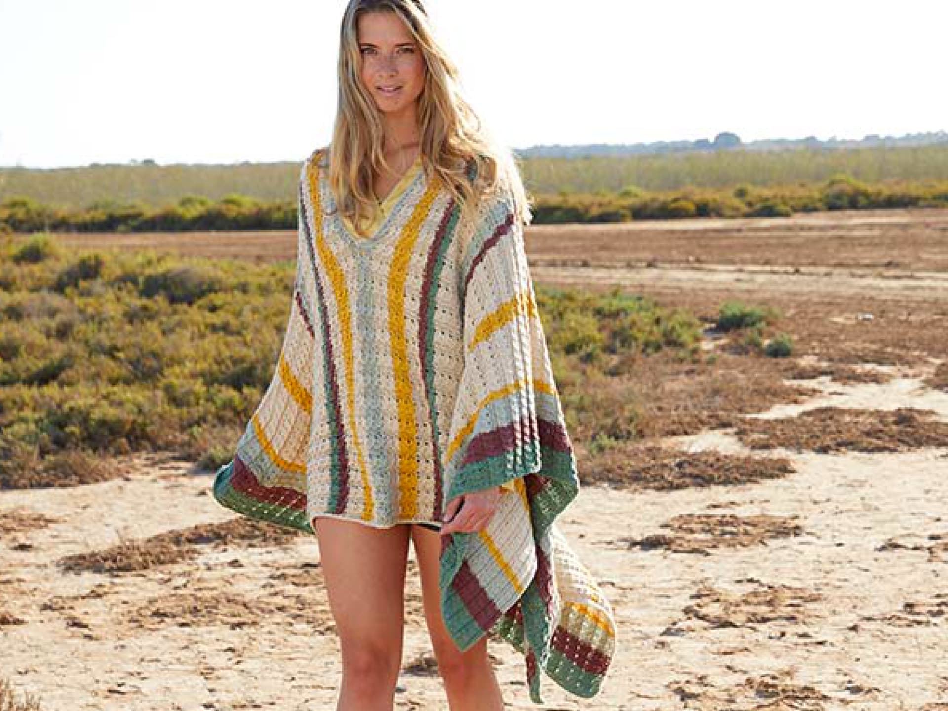 Model in einem bunten Poncho-Kleid von Lana Grossa