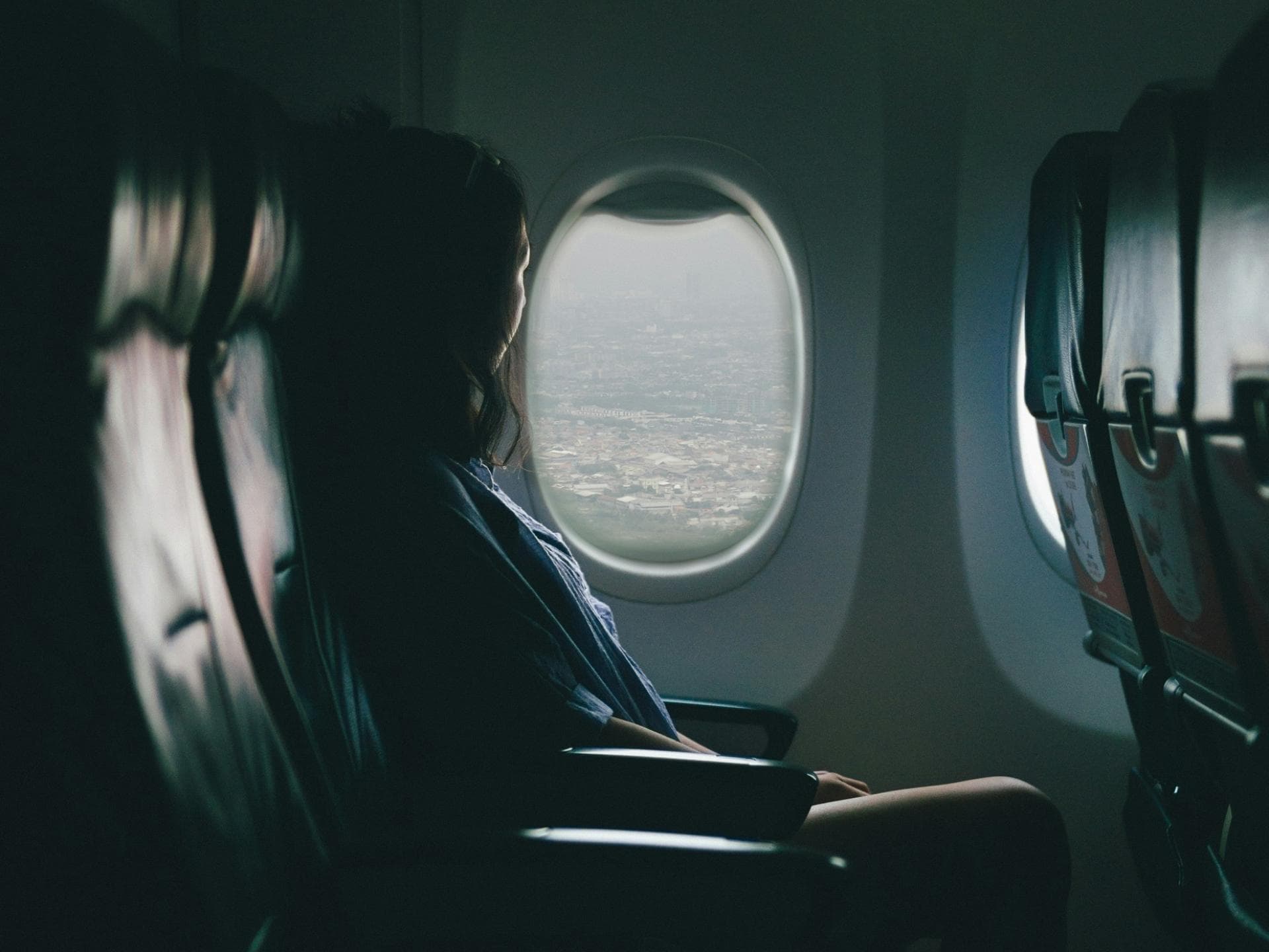 Frau sitzt im Flugzeug am Fenster. Frau sitzt im Flugzeug am Fenster.