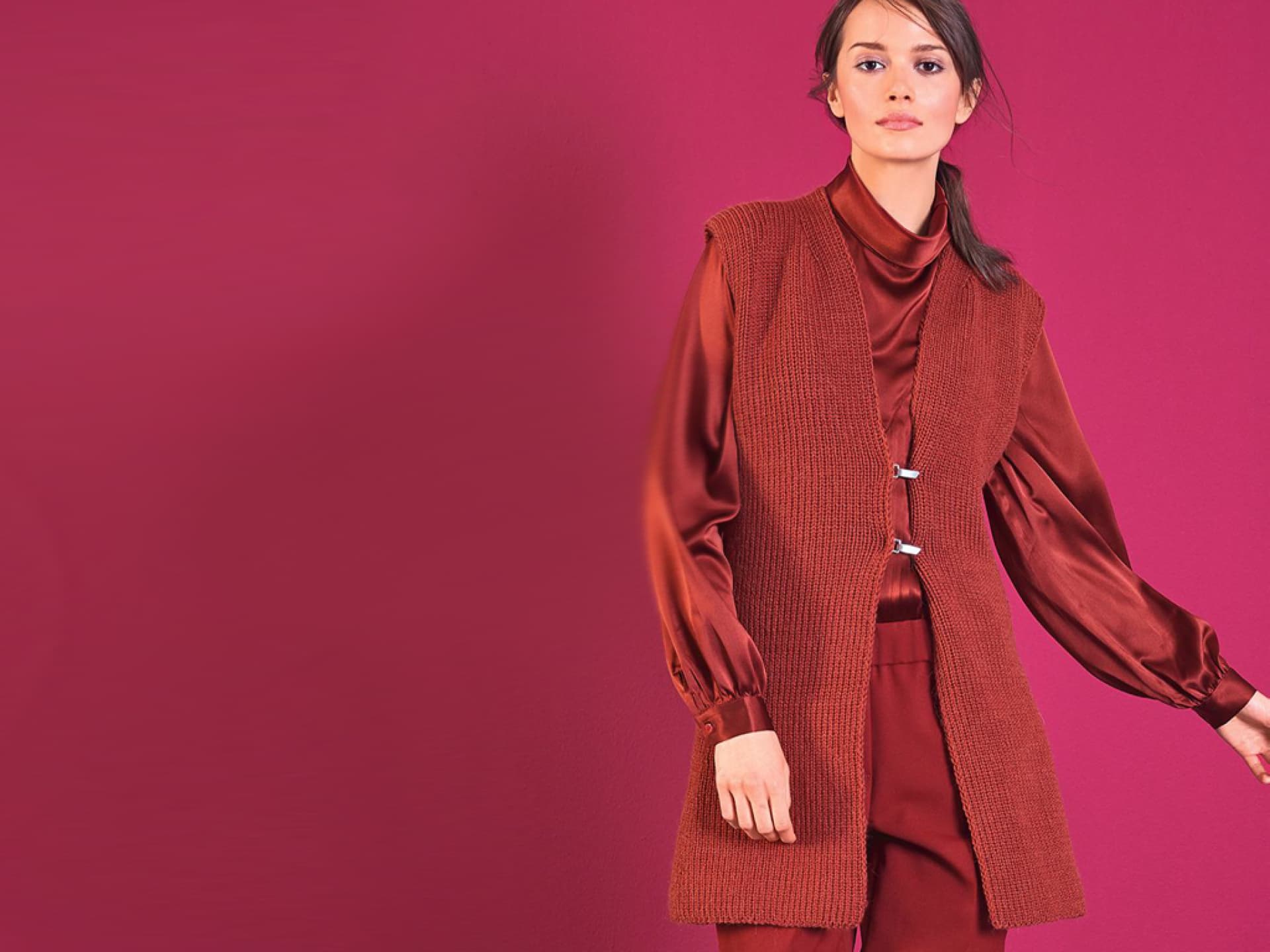 Model in roter Strickweste mit Metallverschlüssen