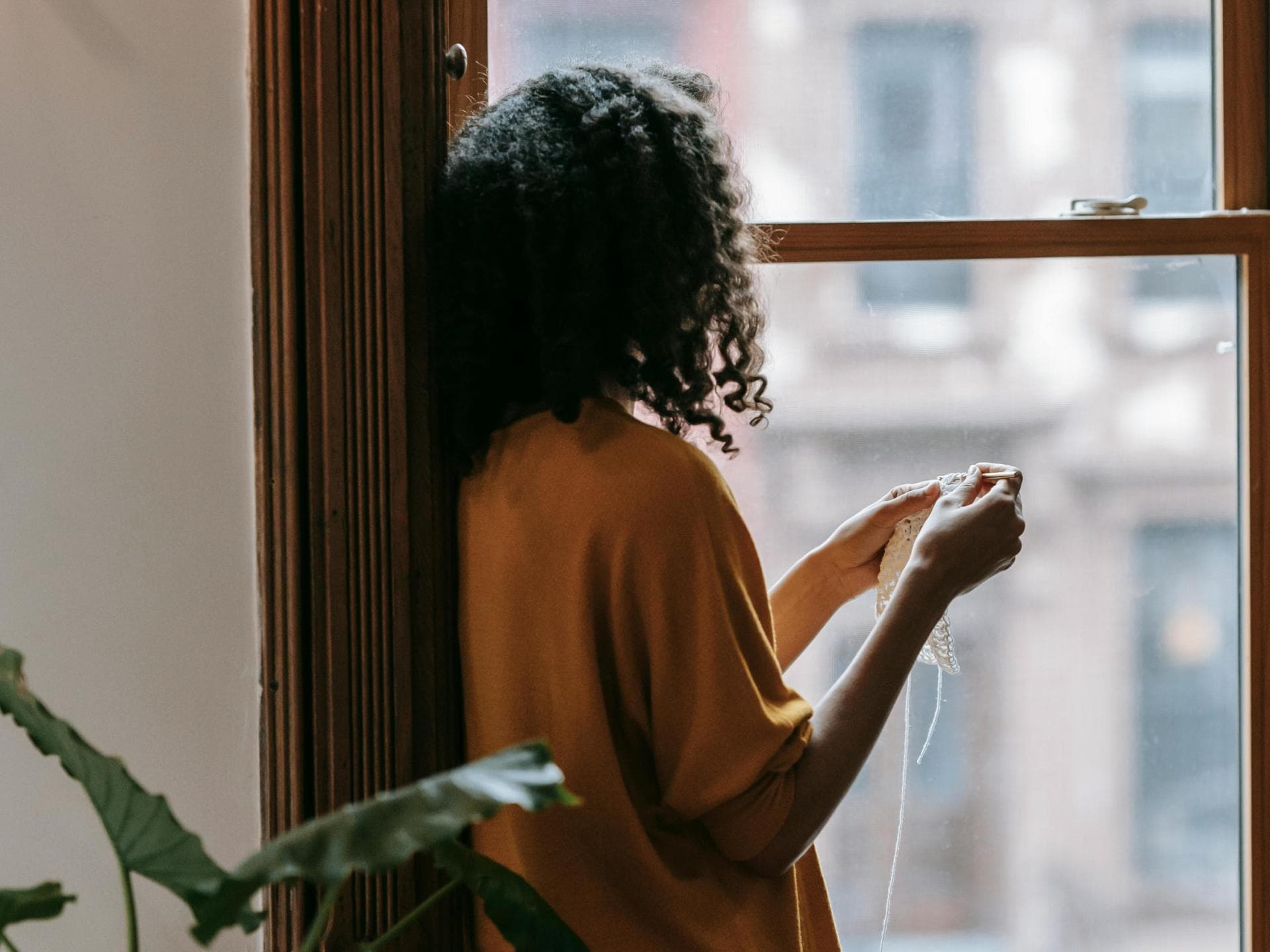 Eine einsame Frau blickt aus dem Fenster
