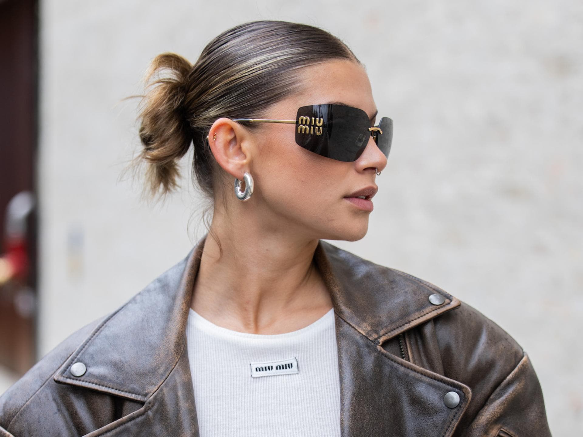 Ein Sleek Dutt ist eine beliebte Frisur bei Regen. Frau mit Sleek Frisur und Sonnenbrille