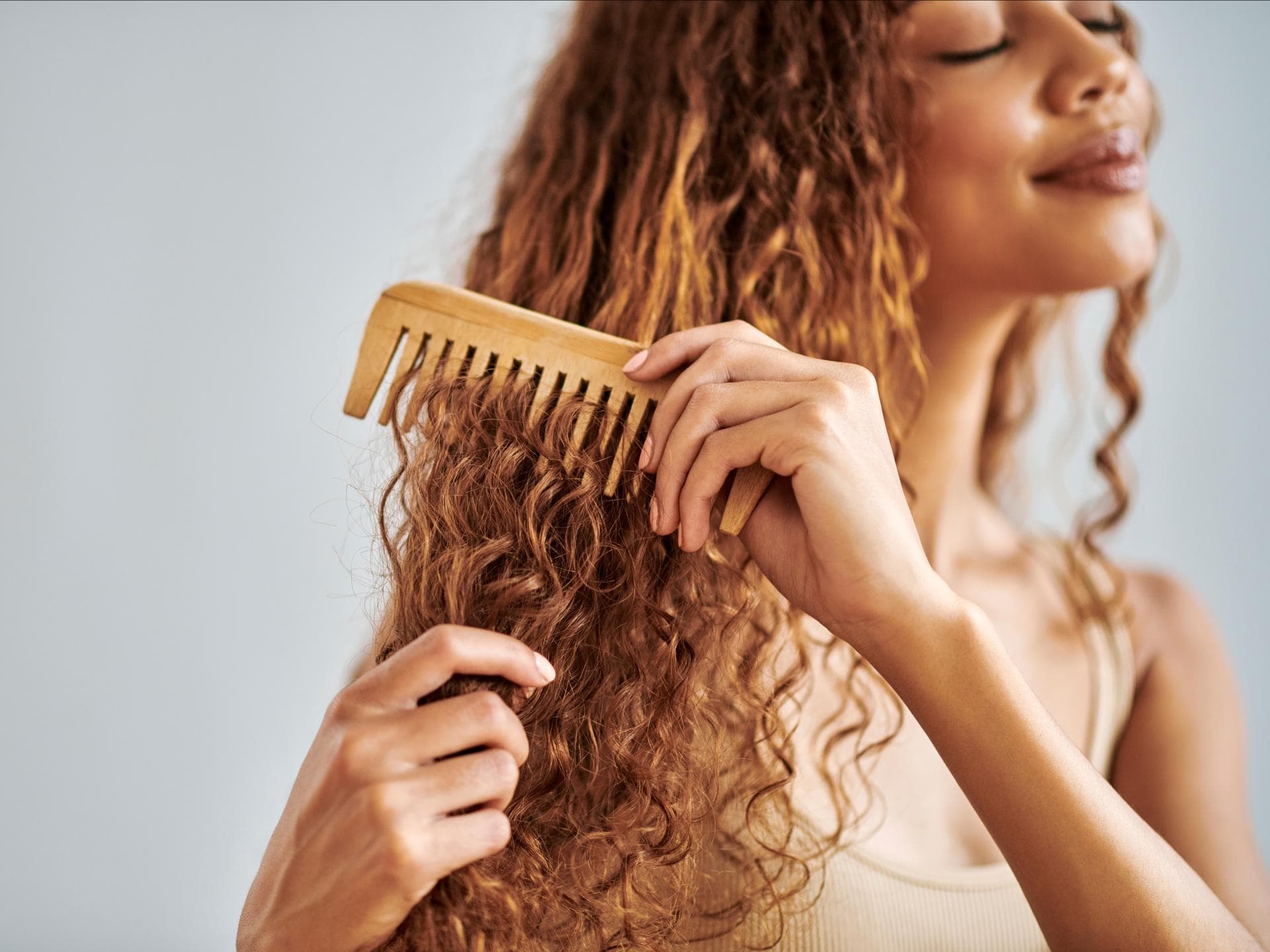Frau kämmt lockige Haare
