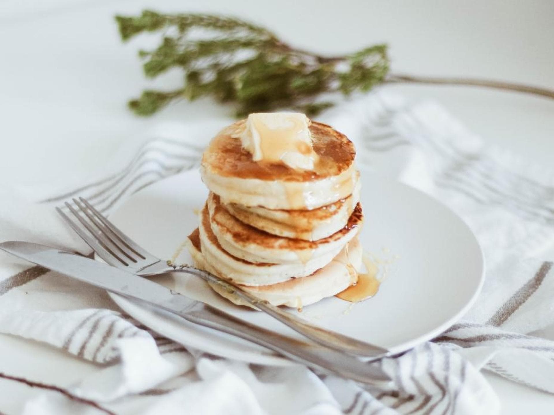 Fluffige Pancakes mir Sirup und Butter