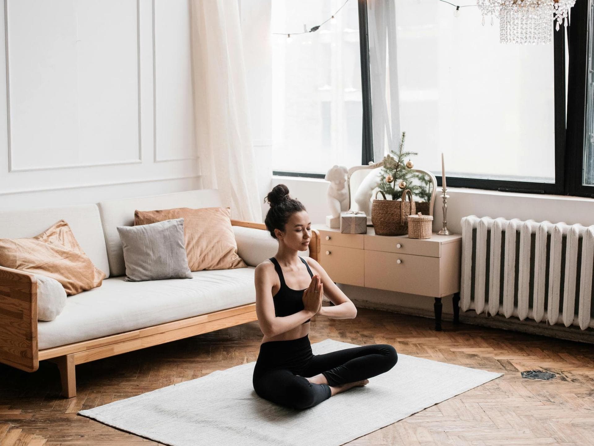 Frau sitzt auf dem Boden und macht eine Yoga Pose