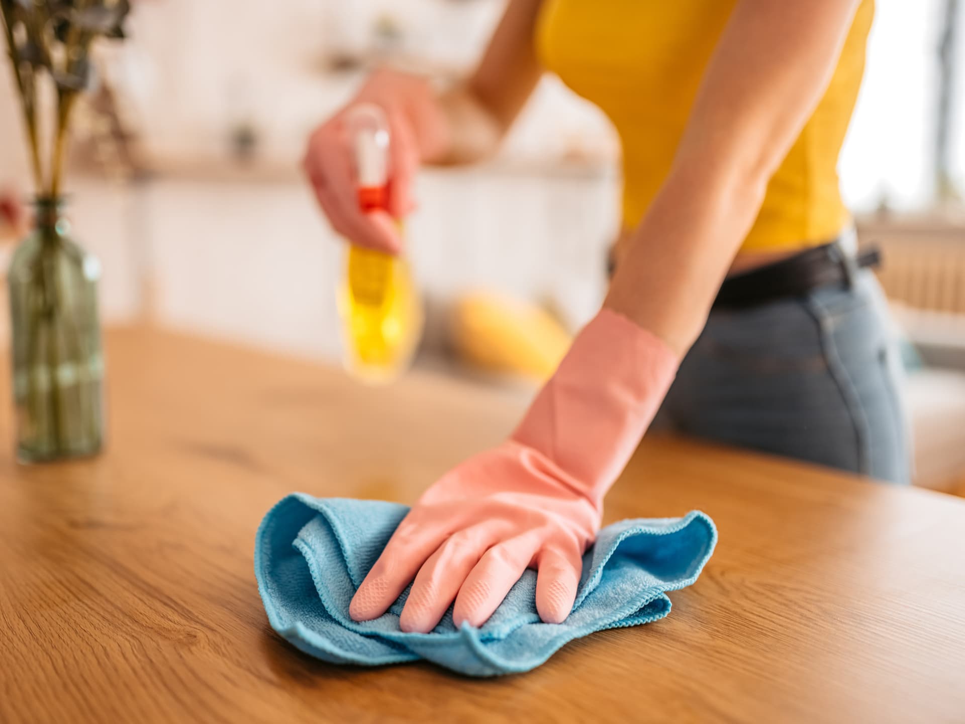 Frau entfernt Staub mit Hausmitteln