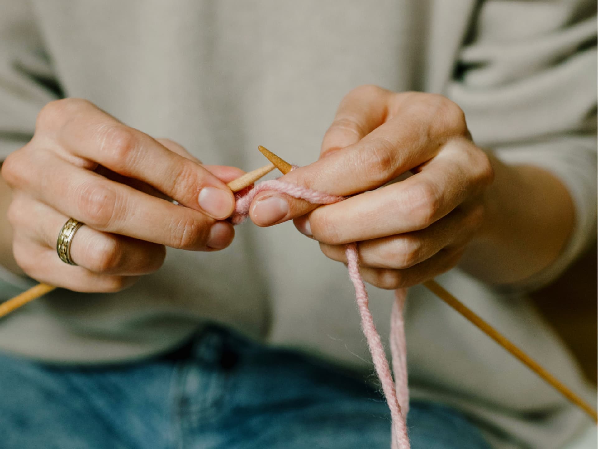 Maschen aufnehmen - Schritt für Schritt erklärt! Frau lernt Maschen aufzunehmen, um Stricken zu lernen