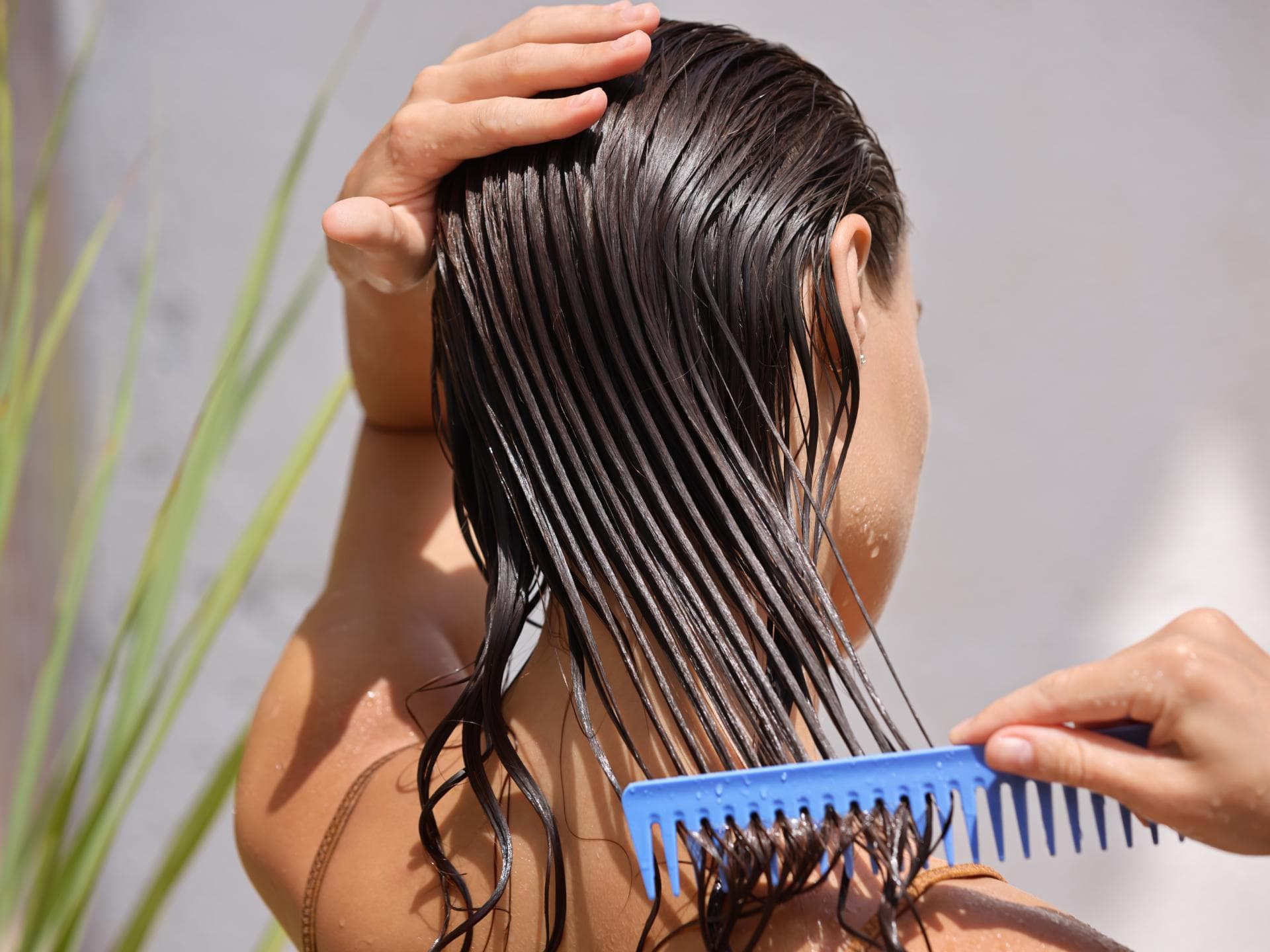 Eine Frau kämmt nasse Haare.
