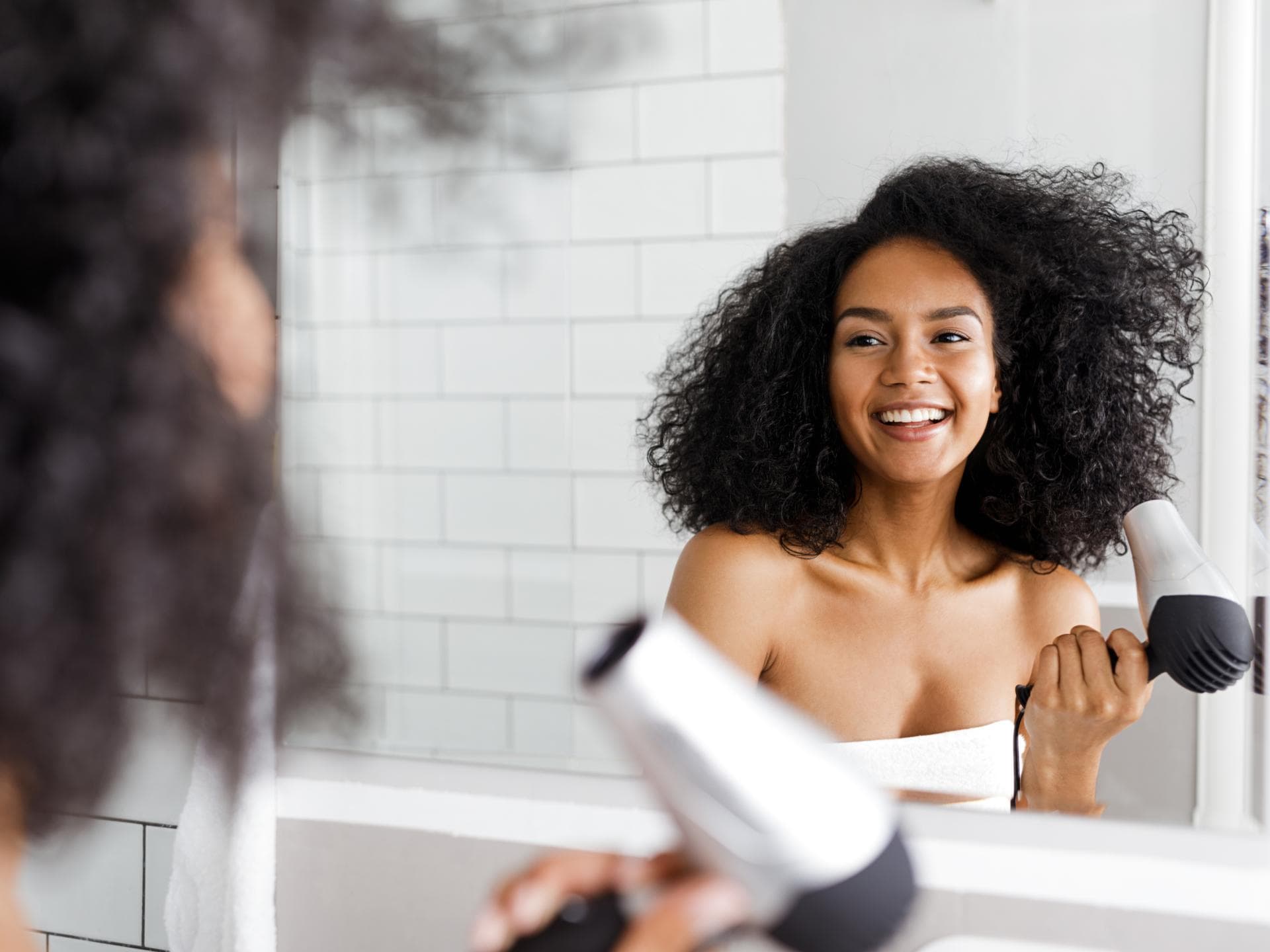 Frau föhnt Locken