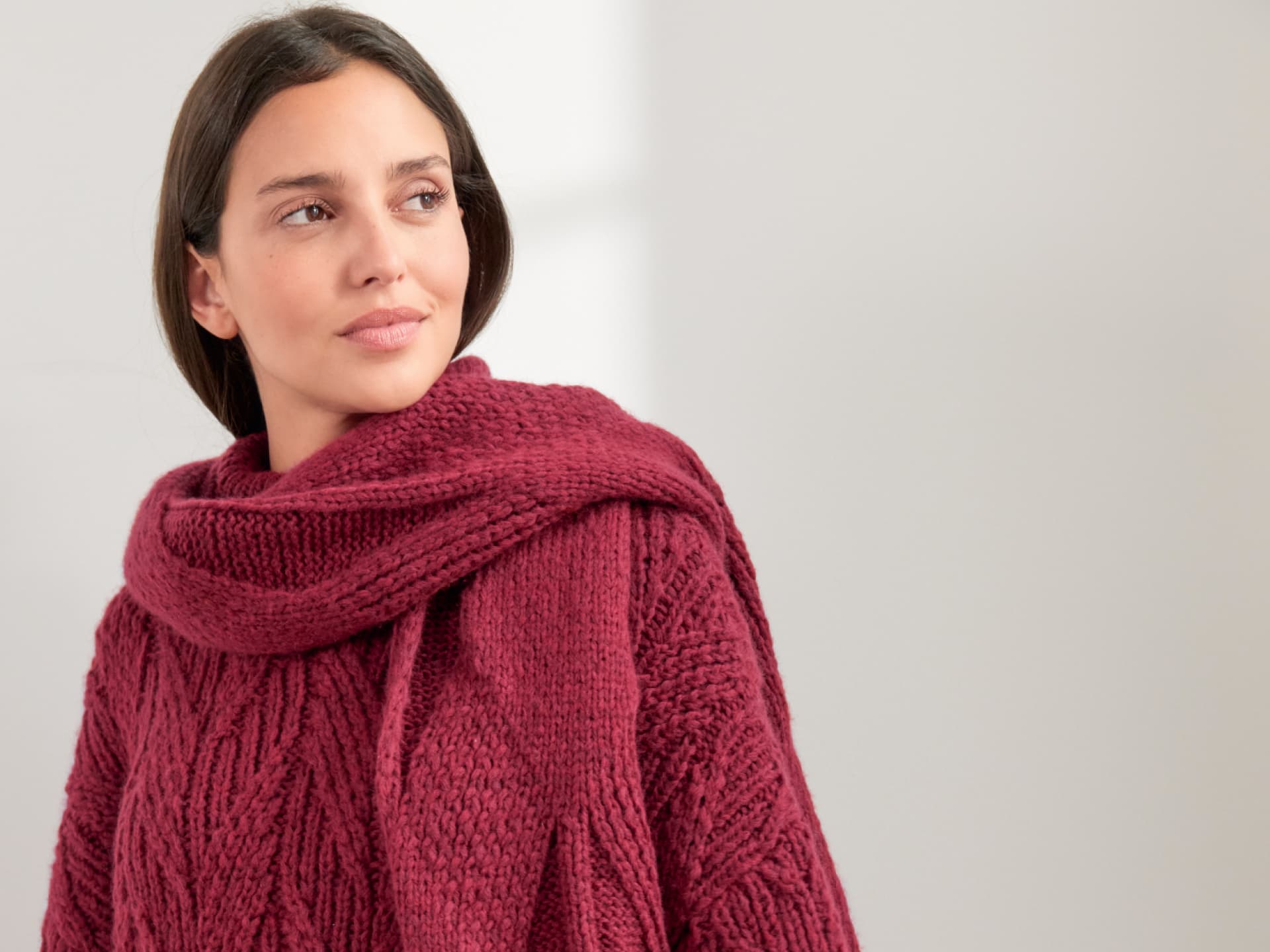 Model in Rautenschal und Pullover in Beerentönen von Lana Grossa