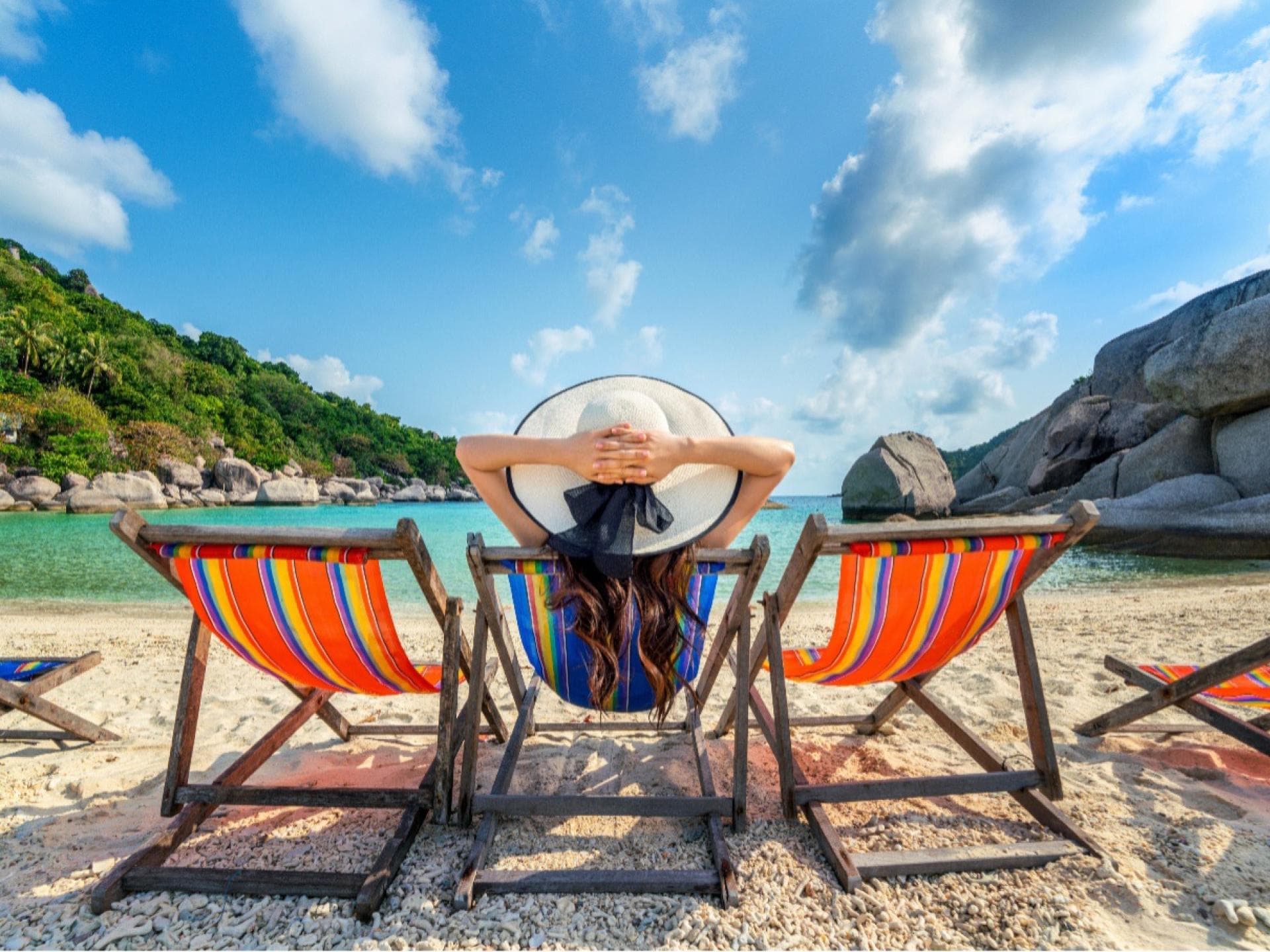 Eine Frau liegt im Liegestuhl am Meer